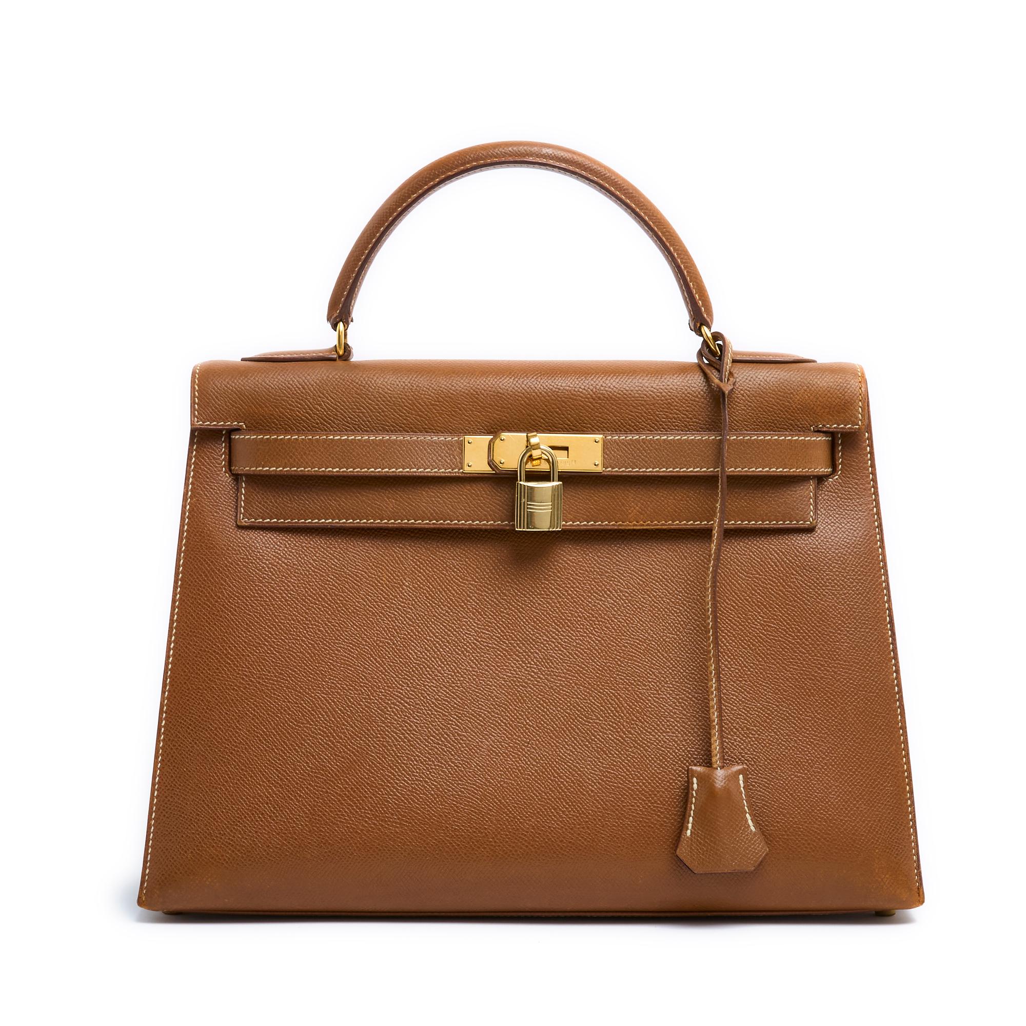 Hermès bag, Kelly model, size 32, in camel or gold grained leather and gold metal (brass), interior lined with coordinated leather with 1 large pocket closed by a zip and a leather zipper and a large double patch pocket, year 1997 and a Kelly
