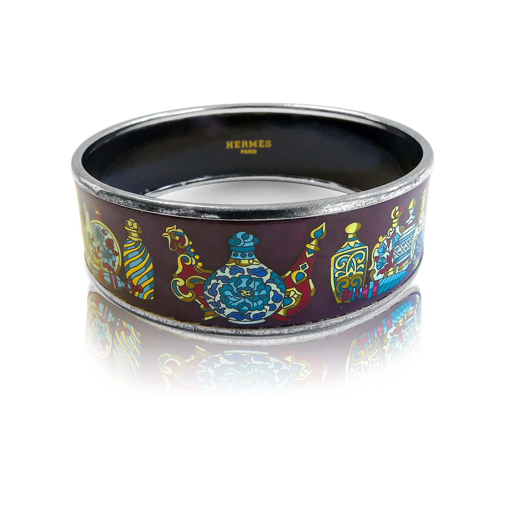 This Hermes bangle features platinum plated with a printed jars pattern enamel. Carved in Austria, It weighs 48 grams, 22mm wide and has an inner diameter of 2.5 inches to give a comfortable fit in your wrist.
