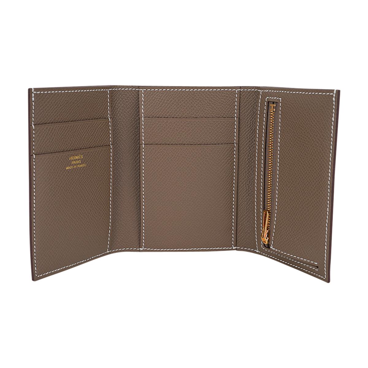 Mightychic offers an Hermes Bearn Combine Trifold Wallet featured in Etoupe.
White topstitch over Epsom leather.
Gold hardware.
The wallet has a tab flap through the iconic H for closure.
Inside the wallet opens to reveal 1 pocket for bills, 4 slot