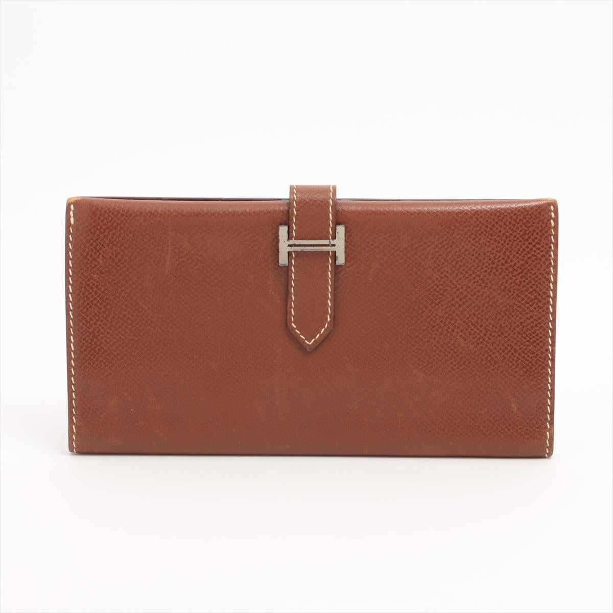 The Hermès Bearn Veau Epsom Wallet in brown is a sophisticated and timeless accessory crafted from durable Epsom leather. Known for its sleek design and impeccable craftsmanship, the wallet features a signature “H” tab closure that adds a refined