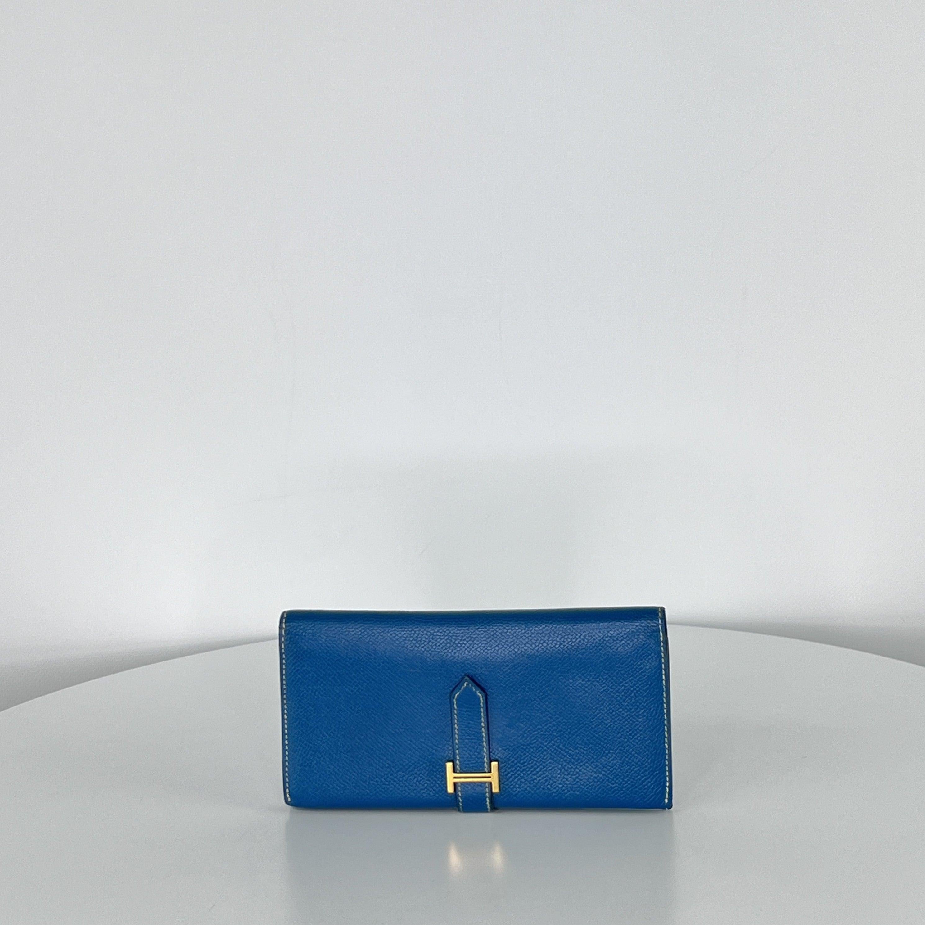 Hermès Béarn wallet in blue leather with gold-tone “H” tab closure. Timeless and elegant design with multiple card slots and compartments. Date code ☐N (2010), made in France.
The wallet is in very good condition; lightly worn and well