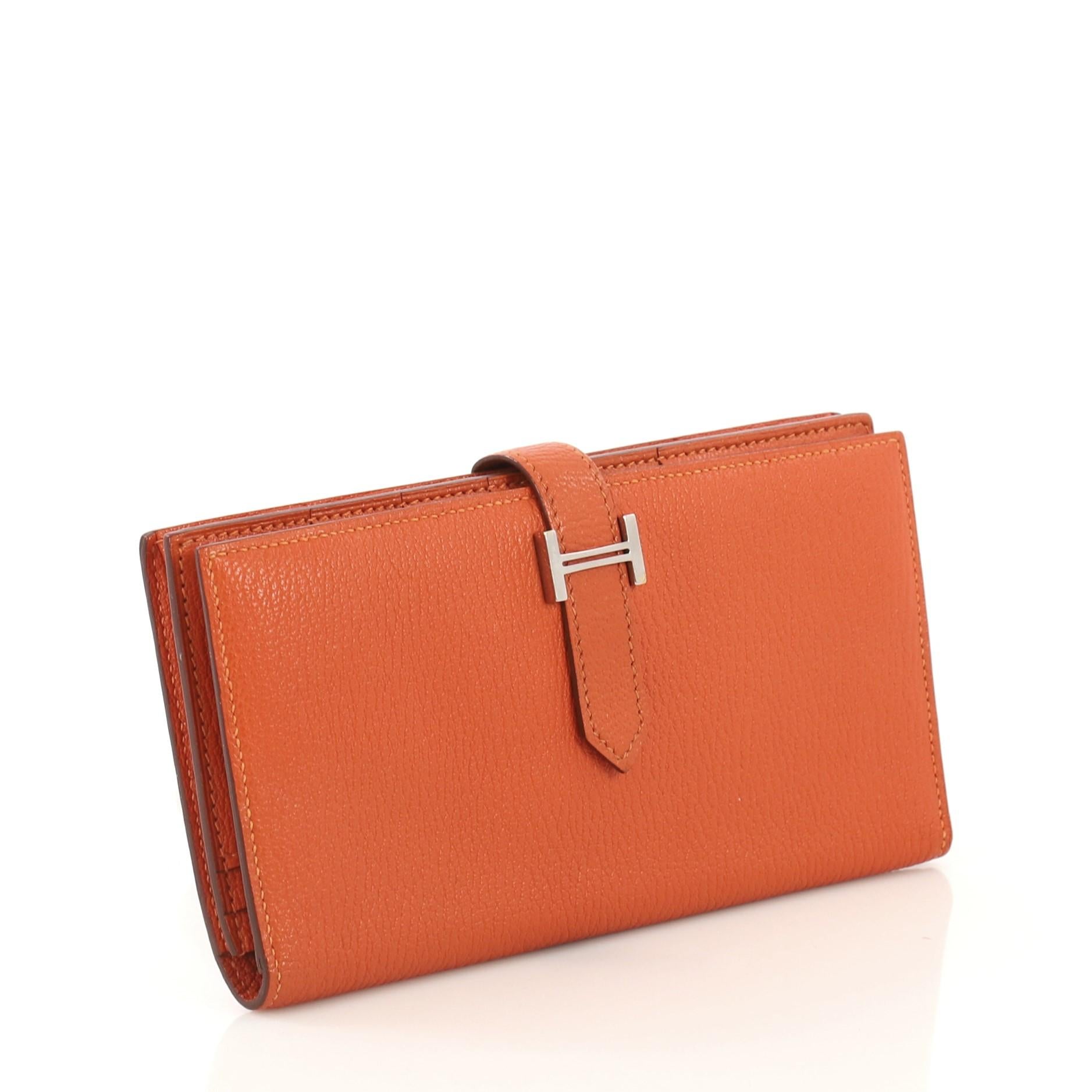 This Hermes Bearn Wallet Chevre Mysore Long, crafted from Orange H orange Chevre Mysore leather, features a plated 'H' tab closure and palladium hardware. Its tab closure opens to an Orange H orange Chevre leather interior with multiple card slots