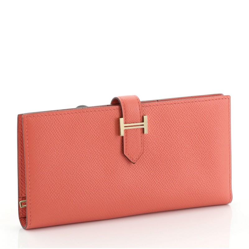 This Hermes Bearn Wallet Epsom Long, crafted from Rose Jaipur pink Epsom leather, features a plated 'H' tab closure and gold hardware. Its tab closure opens to a Rose Jaipur pink Epsom leather interior with multiple card slots and zip pocket. Date
