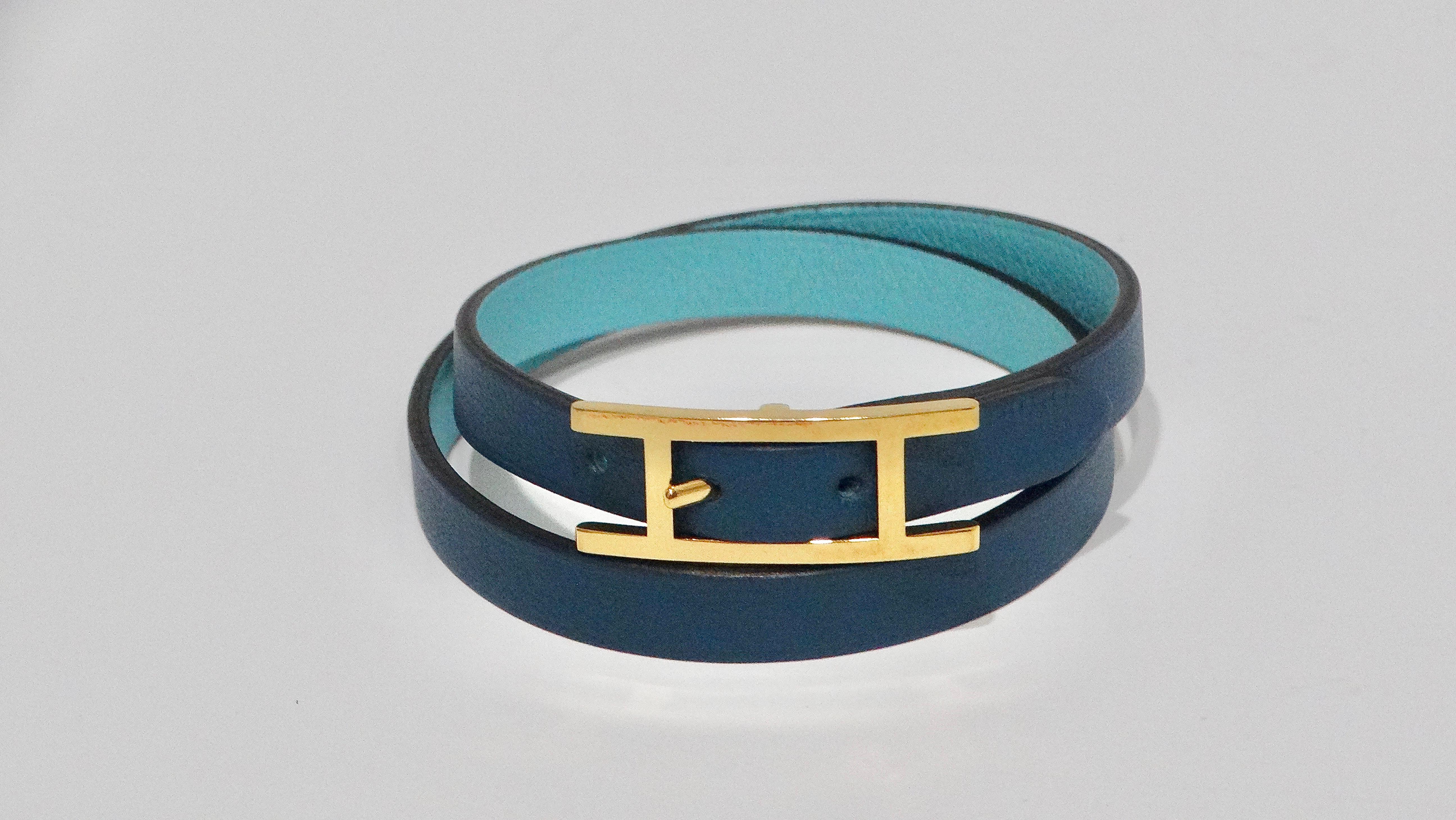 La pulsera Hermès Behapi Double Tour de cuero azul bicolor es la quintaesencia de la elegancia discreta y la sofisticación. Fabricada en Francia, esta pulsera presenta un elegante diseño de cuero azul en dos tonos con un interior azul más claro, y