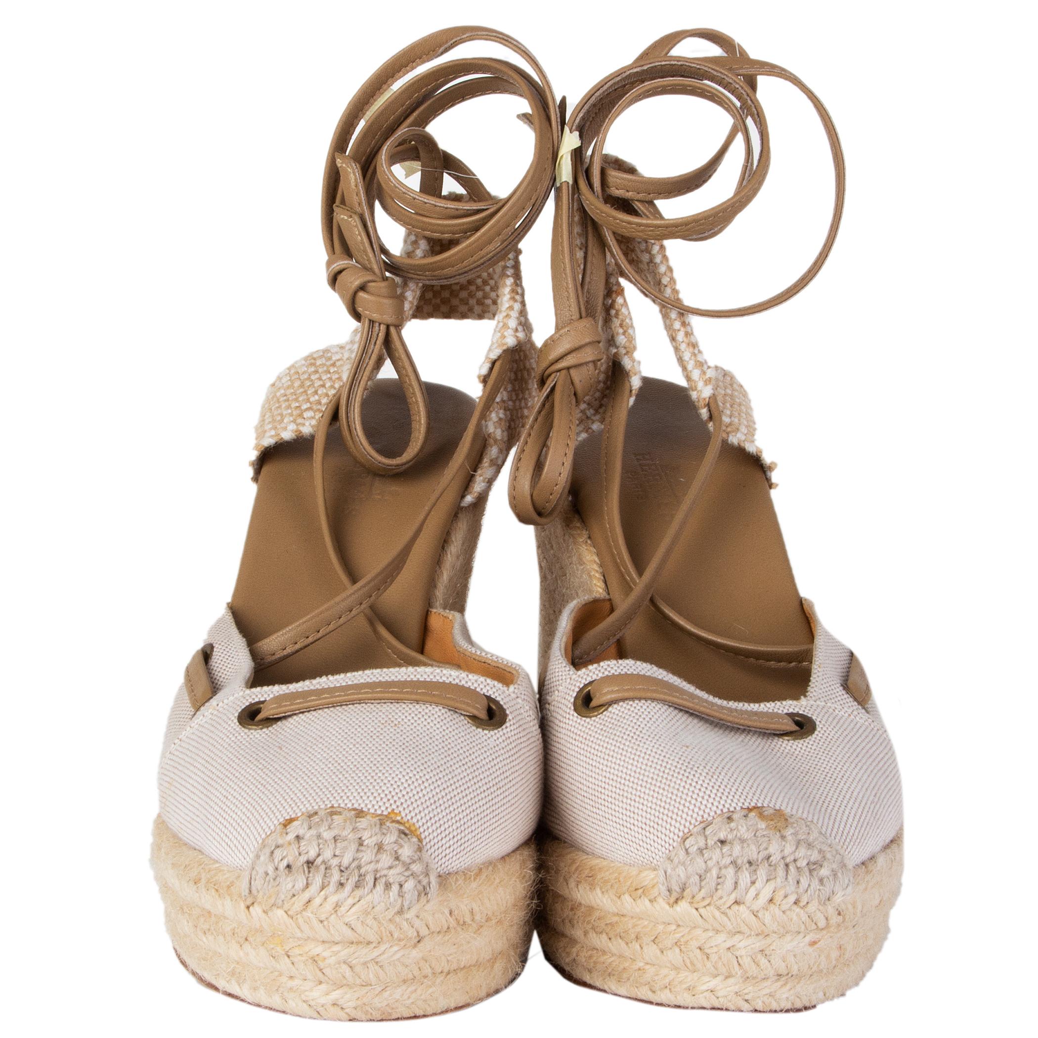 100% authentic Hermès espadrilles in off-white canvas and raffia featuring lace-up leather strapes in khaki. Have been worn with some faint glue stains on the tip. Overall condition is excellent. 

Measurements
Imprinted Size	39
Shoe Size	39
Inside
