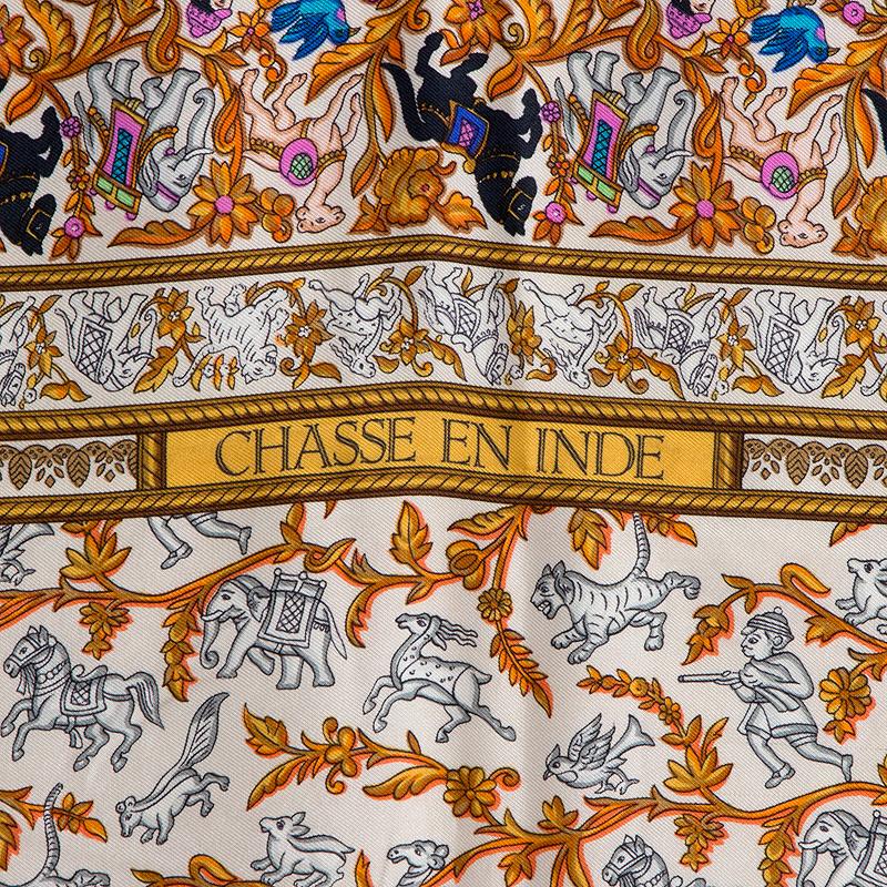 Hermes 'Chasse en Inde' scarf in light beige, orange, gold, brown, ochre, blue, black, pink and grey silk twill. Has been worn with a small whole in the bottom left corner from the dry cleaning tag. Overall impression is very good.

Width 90cm