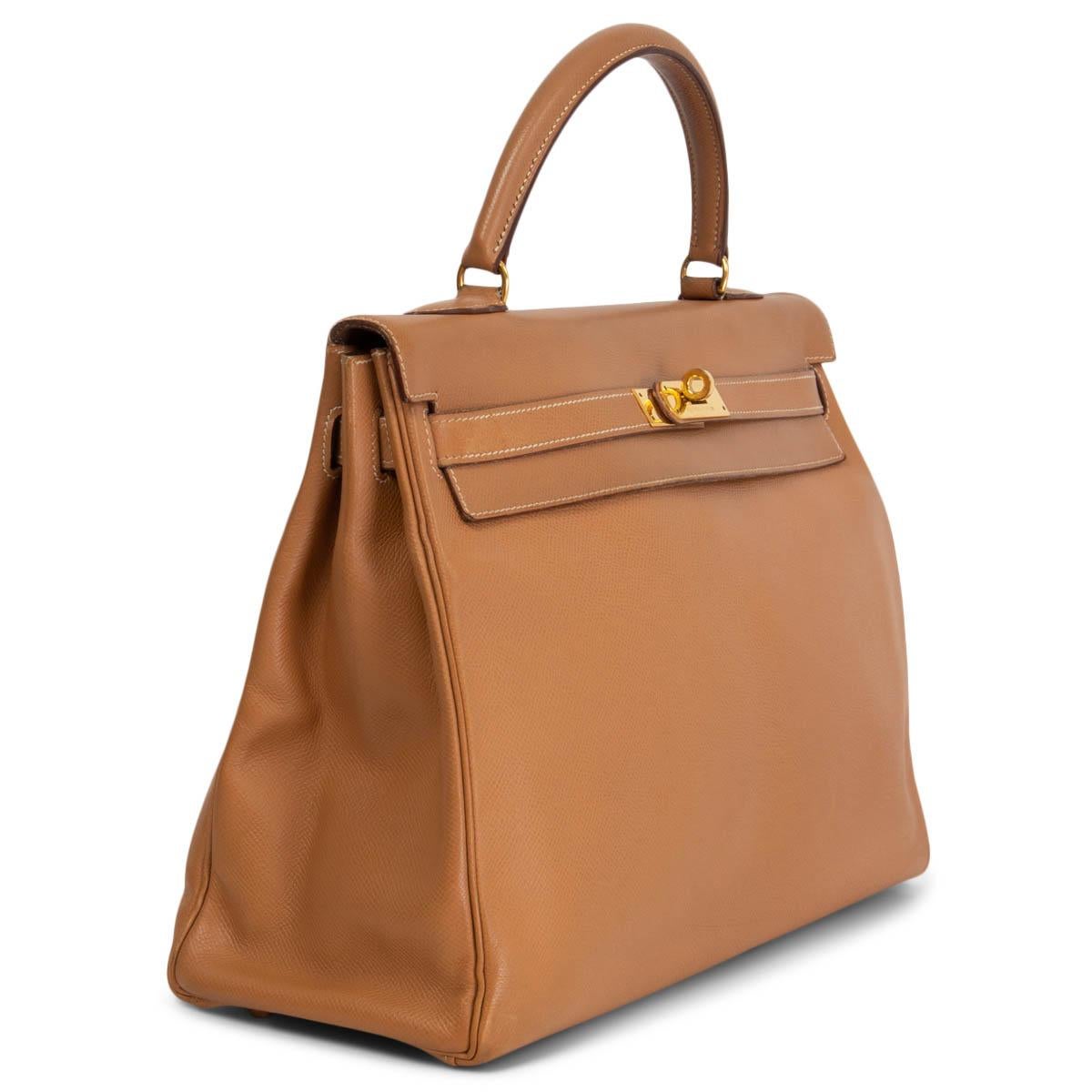 100% authentic Hermès Kelly I 35 Retourne bag in naturelle (light tan) Veau Courchevel leather with contrasting off-white stitching. Lined in Chevre (goat skin) with two open pockets against the front and a zipper pocket against the back. Has been