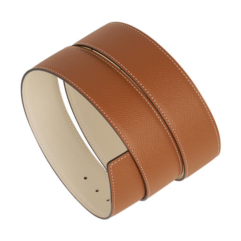 Mightychic offers an Hermes Constance 42 mm belt featured in reversible Gold to Craie Epsom leather.  
Fabulous over sized brushed Gold signature H buckle.  
Now a retired size, this is sure to become a collectors treasure. 
Signature HERMES PARIS