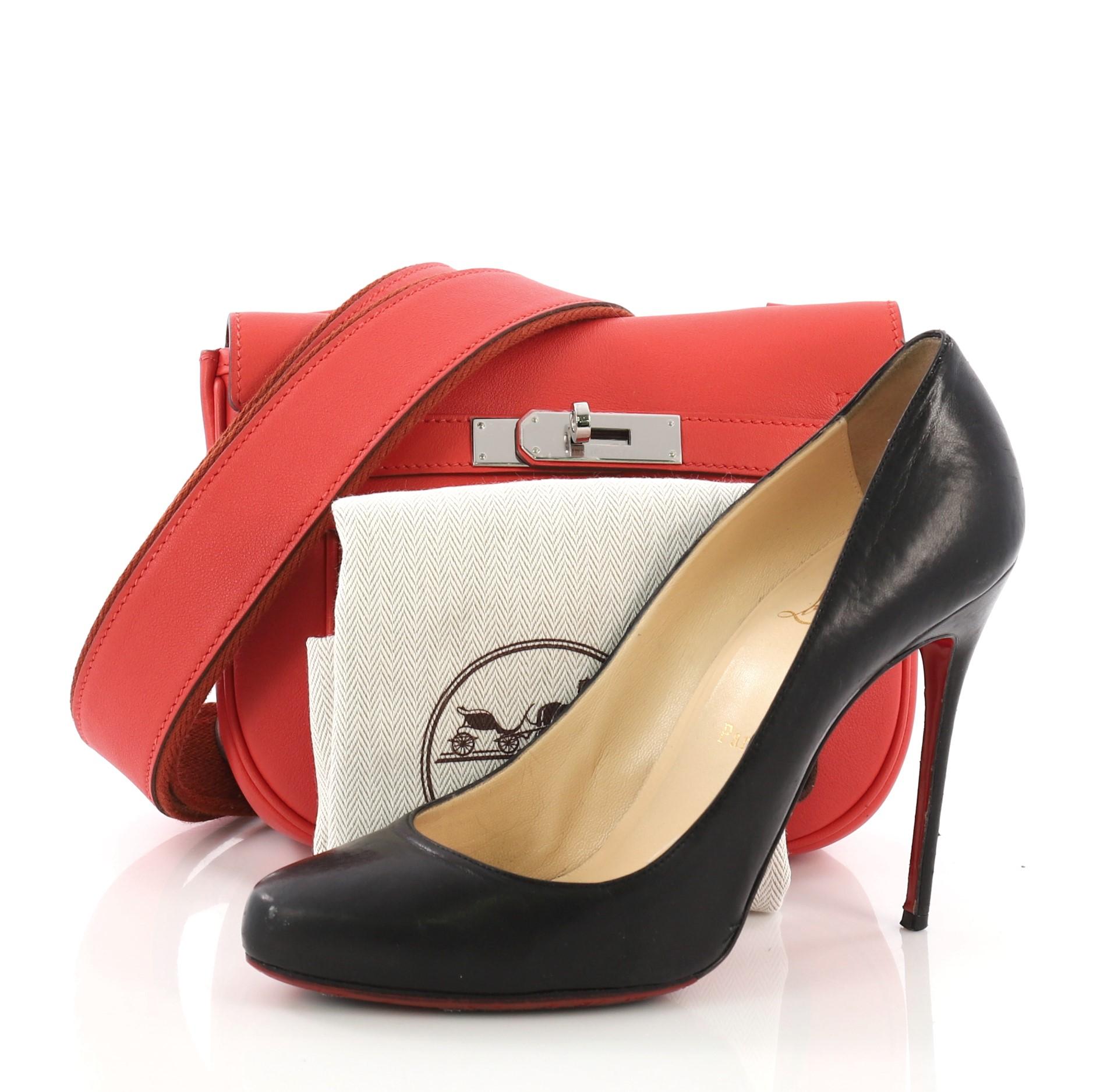 This Hermes Berline Handbag Swift 21, crafted from Capucine red Swift leather, features a paneled design at its front and back body and palladium hardware. Its turn-lock closure opens to a Capucine red Swift leather interior with side zip pocket.