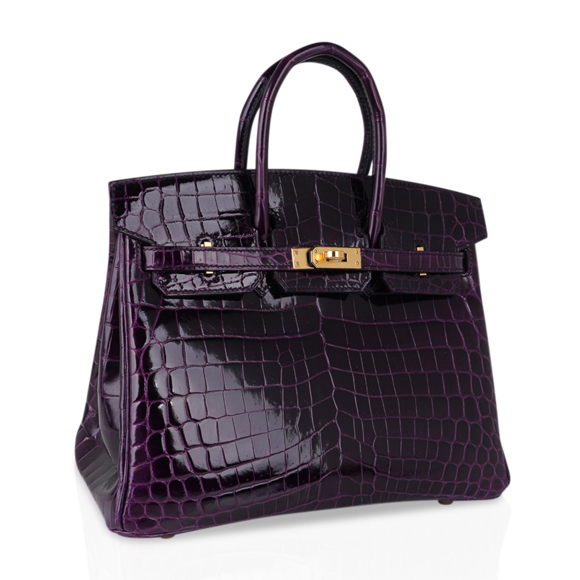 Mightychic offers an Hermes Birkin 25 bag featured in rich, saturated Aubergine crocodile. 
Rarely produced this exquisite jewel toned beauty is a must have for any Hermes aficionado.
This Hermes Birkin bag is lush with gold hardware, and is nothing