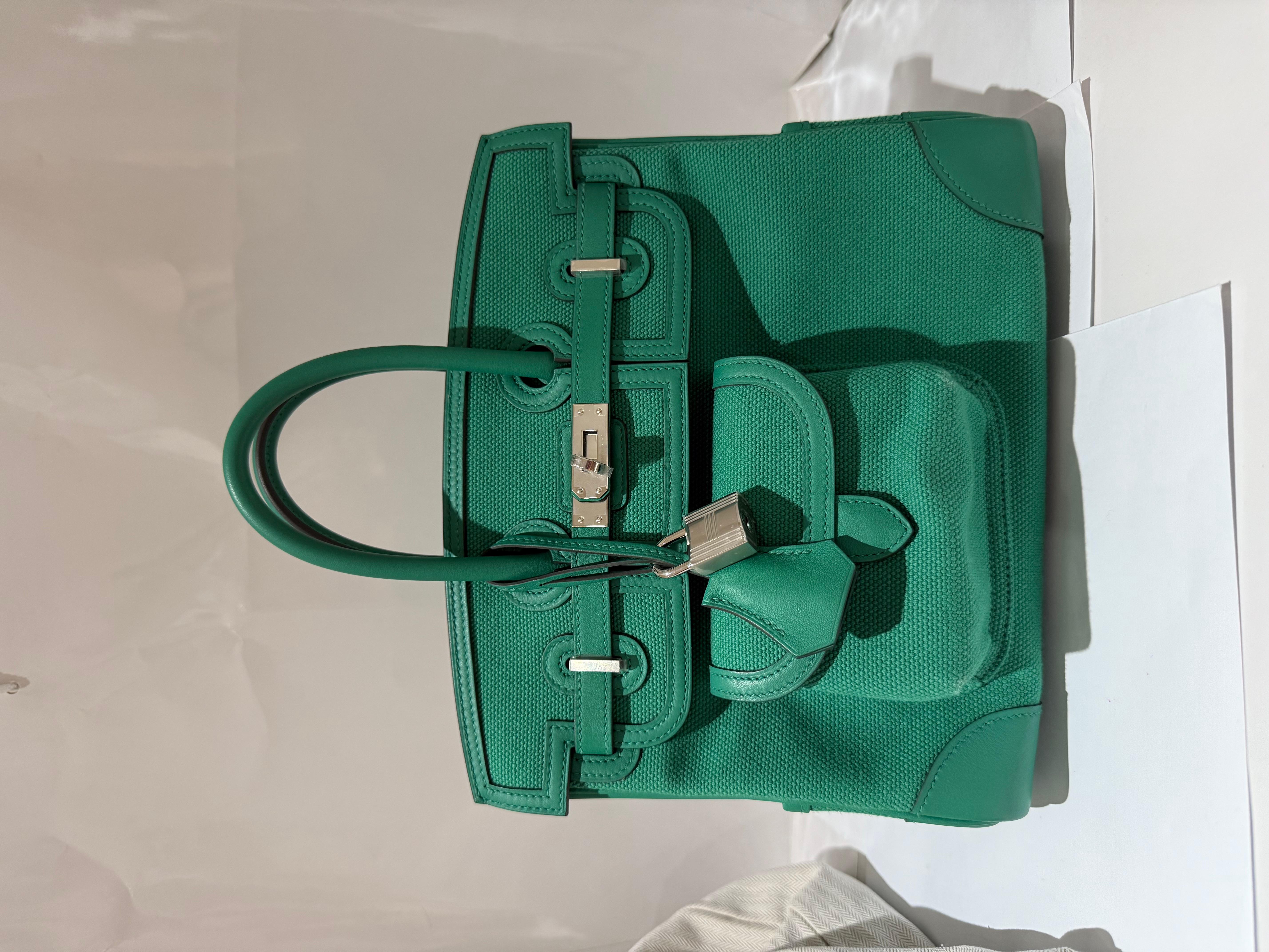 Sac à main Hermes Birkin 25 Vert Vertigo Cargo en Swift et Canvas avec Palladium Hardware. 
Ce sac Birkin 25  est une édition limitée de la collection Cargo, très exclusive et une pièce de collection. 
Comprend une clochette, un cadenas, des clés,