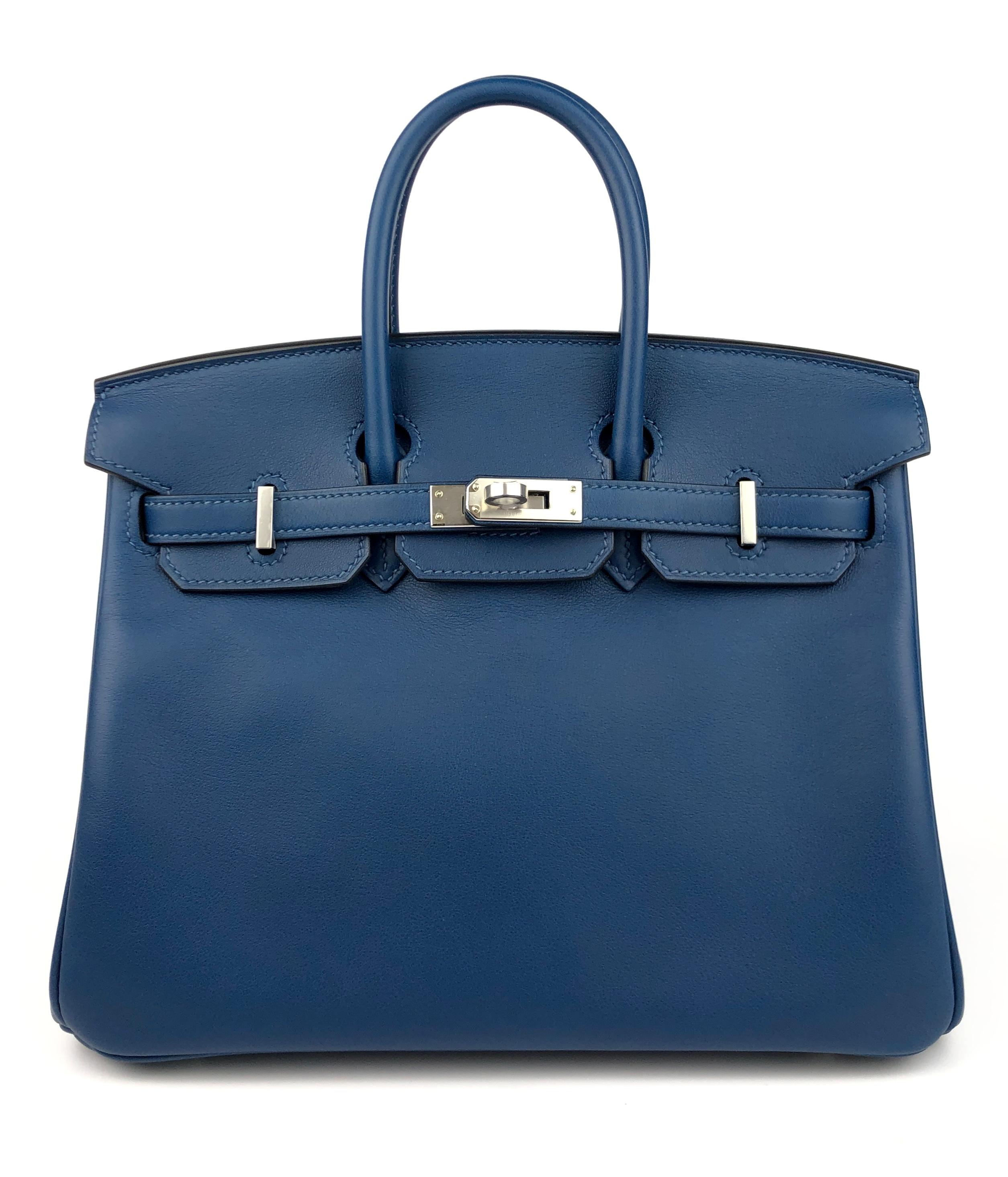 Rare As New 2020 Hermes Birkin 25 Deep Blue Leather complimented by Palladium Hardware. Y Stamp 2020. As New Plastic on all Hardware and feet. Small very minor spot on inside of bag as seen in the photos from storing clochette and raincoat inside.