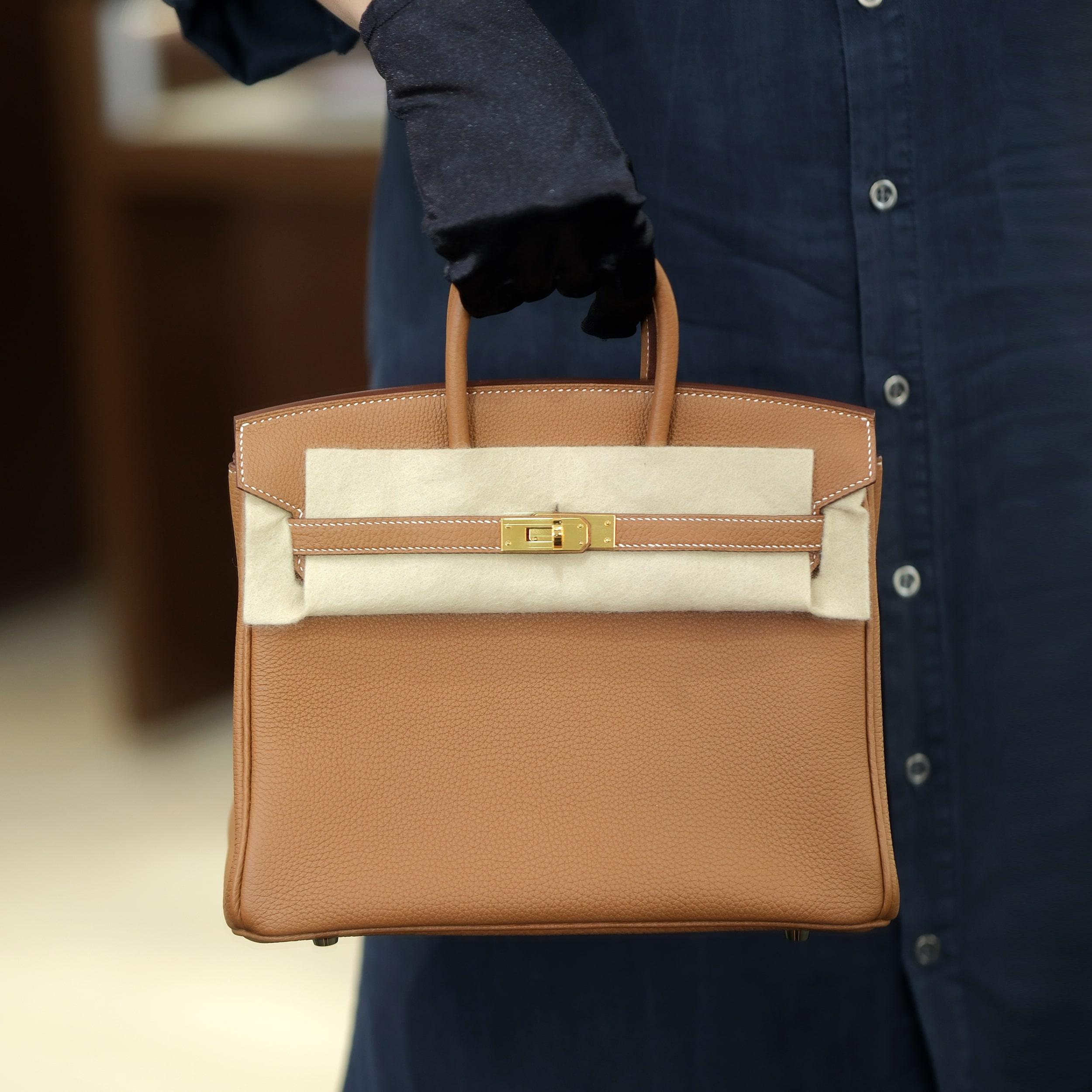 Ce Birkin 25 d'Hermès est réalisé en cuir Gold Togo avec des accessoires dorés. Il incarne la sophistication intemporelle dans un format plus petit et très convoité. Il est doté de coutures contrastées, d'un rabat frontal, de deux bretelles avec