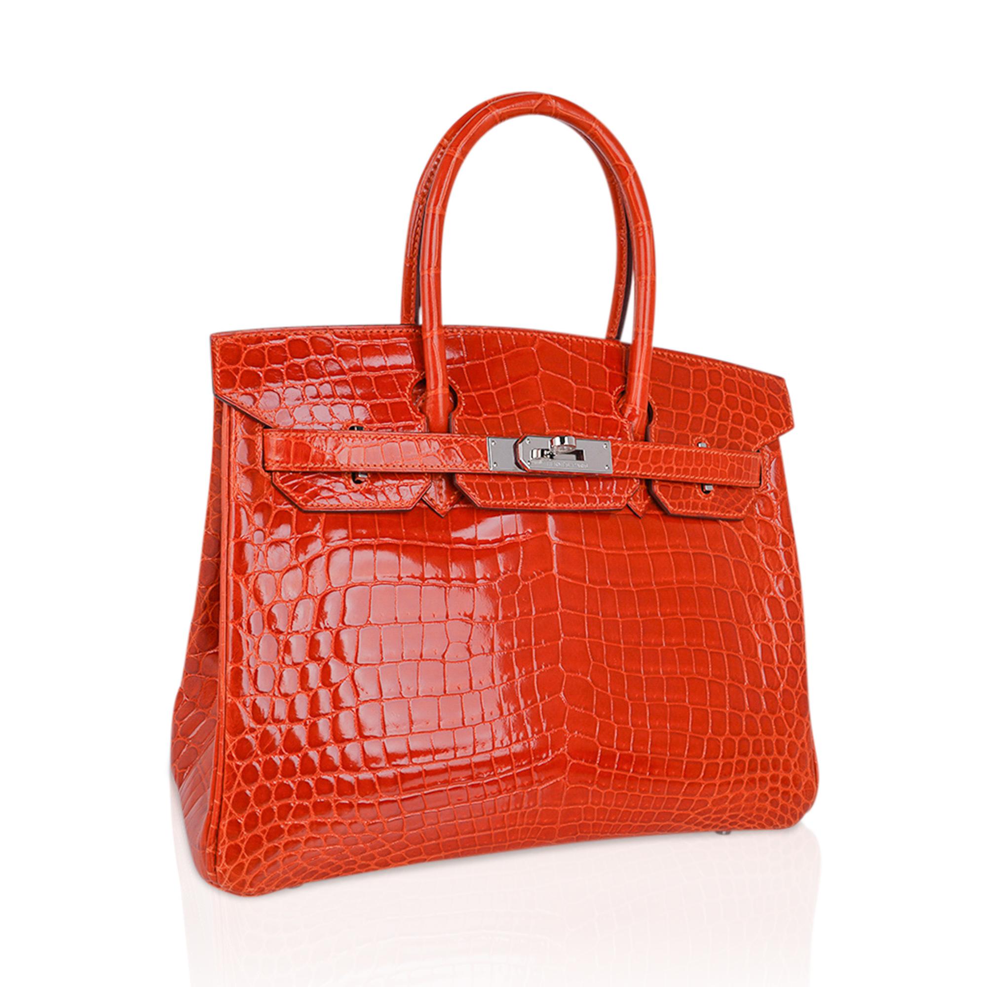 Mightychic offers a Niloticus Crocodile Hermes Birkin 30 bag featured in Orange.
Fresh palladium hardware accentuates this gorgeous orange crocodile Hermes bag. 
Carried 1 time only. Immaculate condition interior and exterior.
This exotic Niloticus
