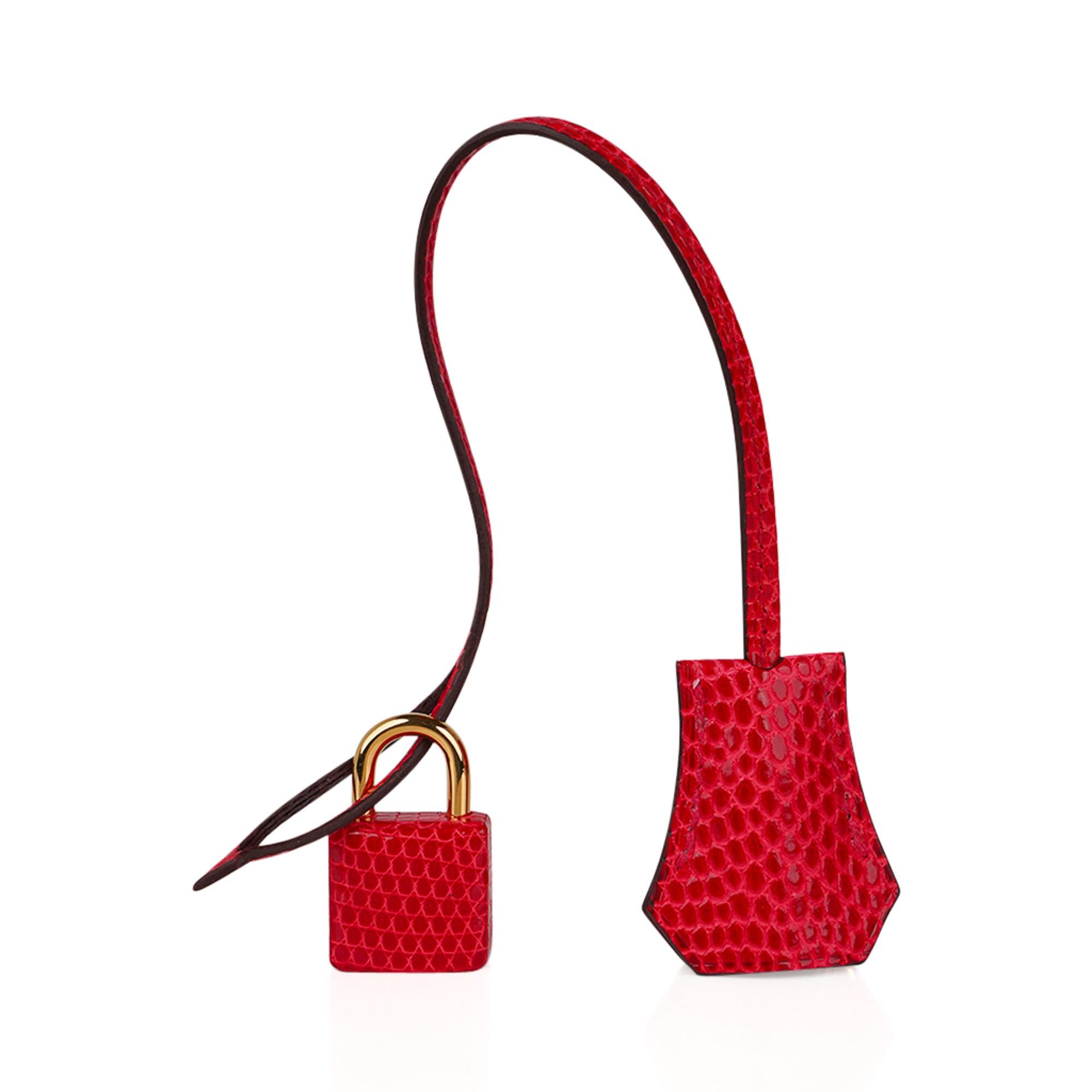 Mightychic offers a guaranteed authentic Rouge Exotique Lizard featured in a limited edition Hermes Birkin 30 bag.
This exquisitely beautiful Hermes bag is featured in a vivid lipstick red.
Lizard only becomes more beautiful and supple with