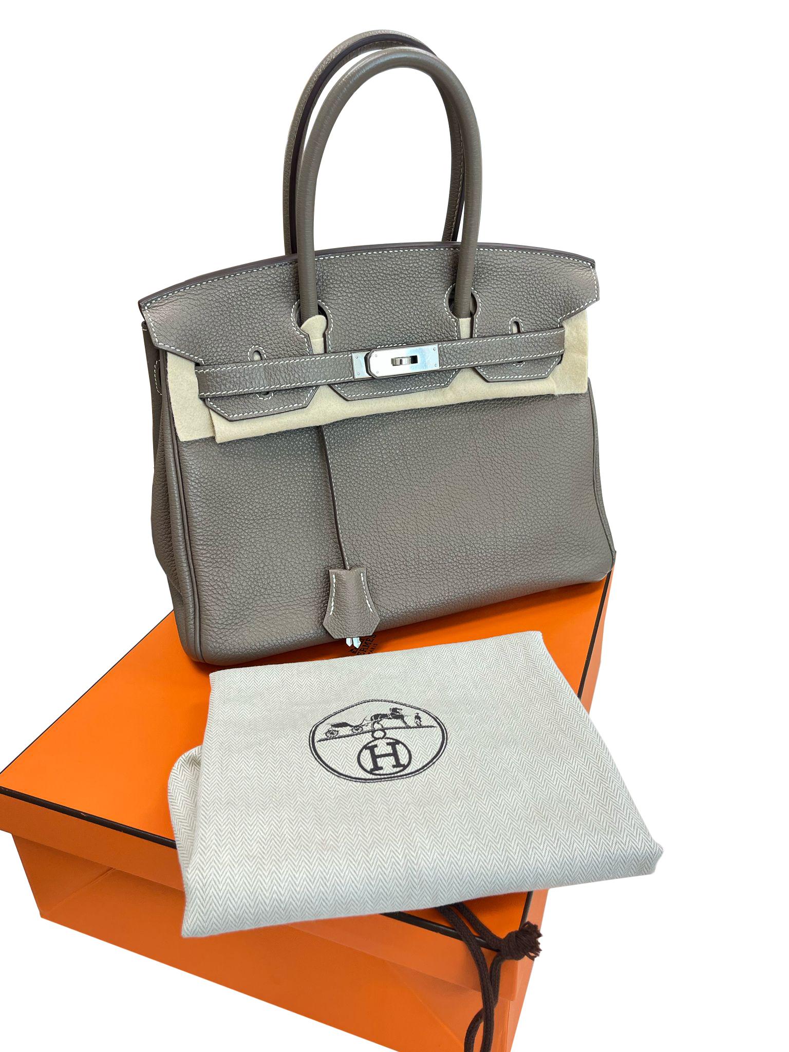 This Birkin is in Etoupe Togo leather with palladium hardware and has contrast stitching, and double-rolled handles. The interior is lined with Etoupe chevre and has one zip pocket with a Hermès engraved zipper pull and an open pocket on the