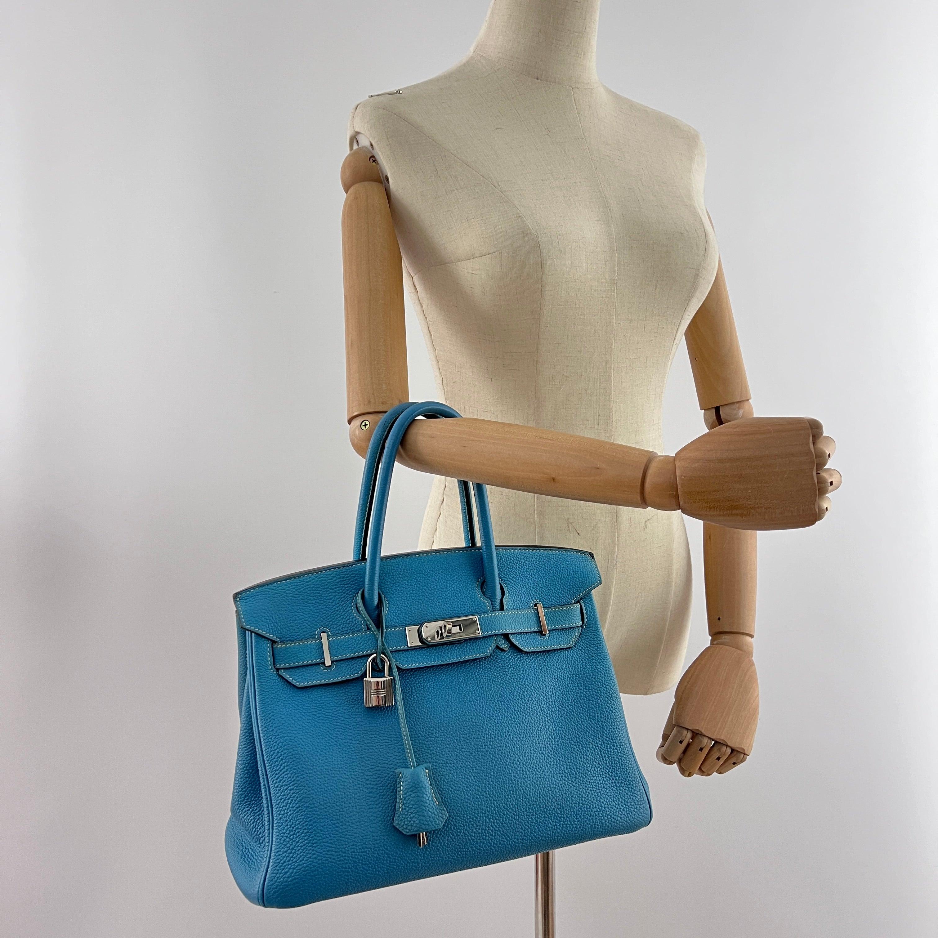 Magnifica Birkin 30 di Hermès realizzata in pelle Blue Jean Togo con finiture in palladio. Serratura a rotazione, clochette e lucchetto, tasche interne con zip e slip.
Codice data ☐N (2010), prodotto in Francia.
Include serratura, chiavi, clochette,