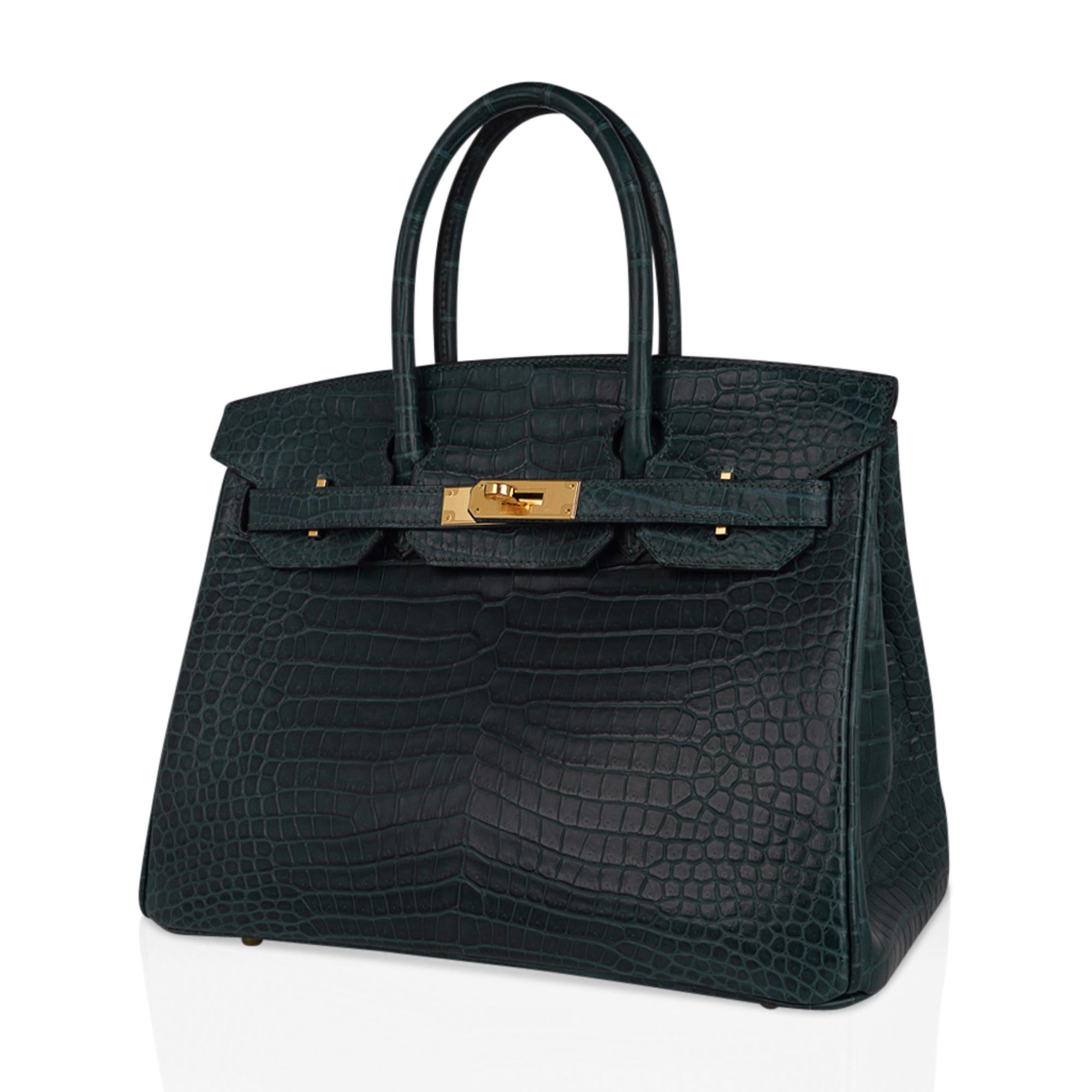 Mightychic offers an exquisite Hermes Birkin 30 bag is featured in in lush deep Vert Fonce Porosus Crocodile. 
This exotic Hermes Birkin bag in matte Porosus crocodile skin has magnificent scales.
The most exclusive and coveted Porosus skin is