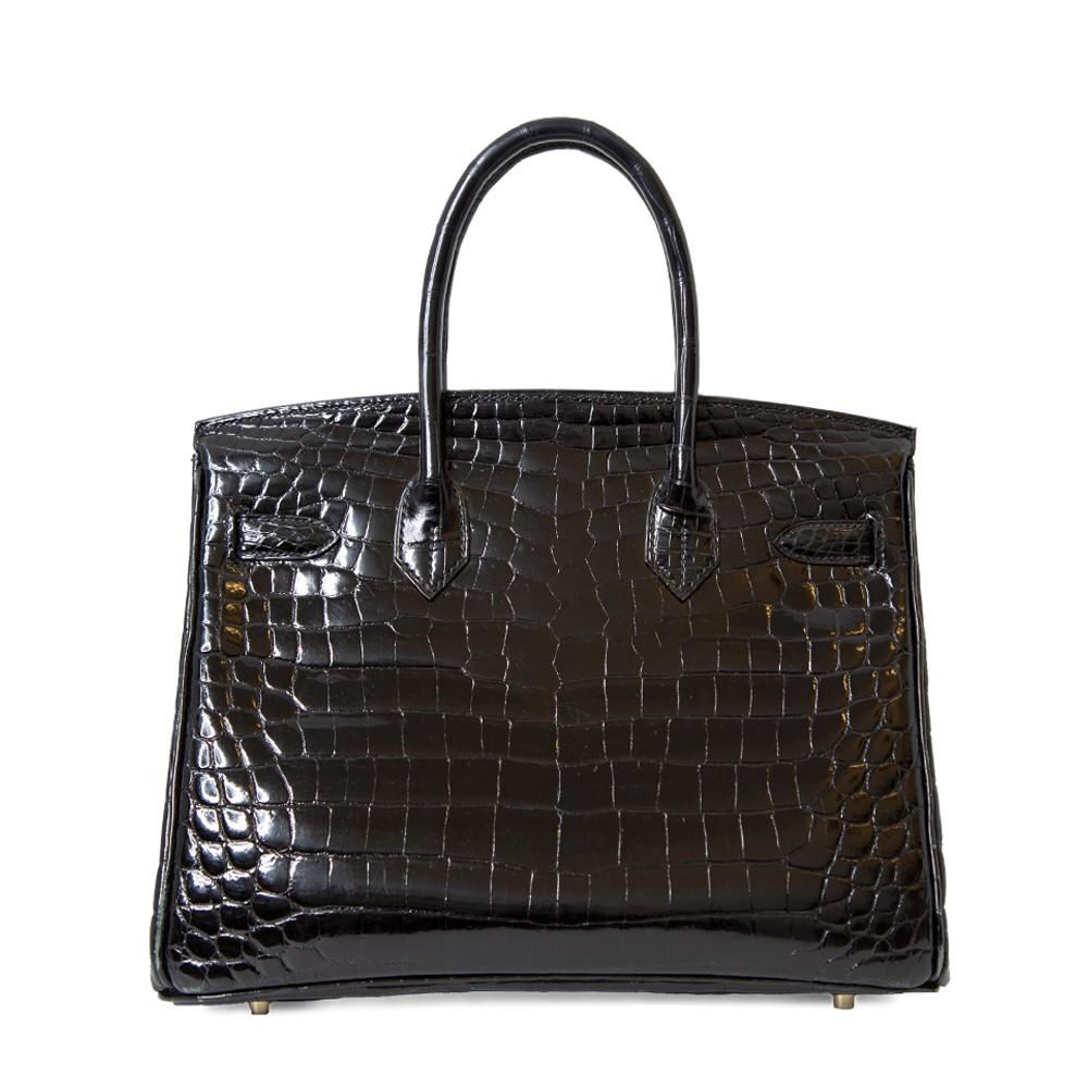 This 30cm Black Shiny GHW Birkin bag is an exquisite work of art. Meticulously crafted in 2009, it stands out with its classic black hue and luxurious gold hardware. Its extravagant rarity makes it a true showstopper.

This piece does show signs of