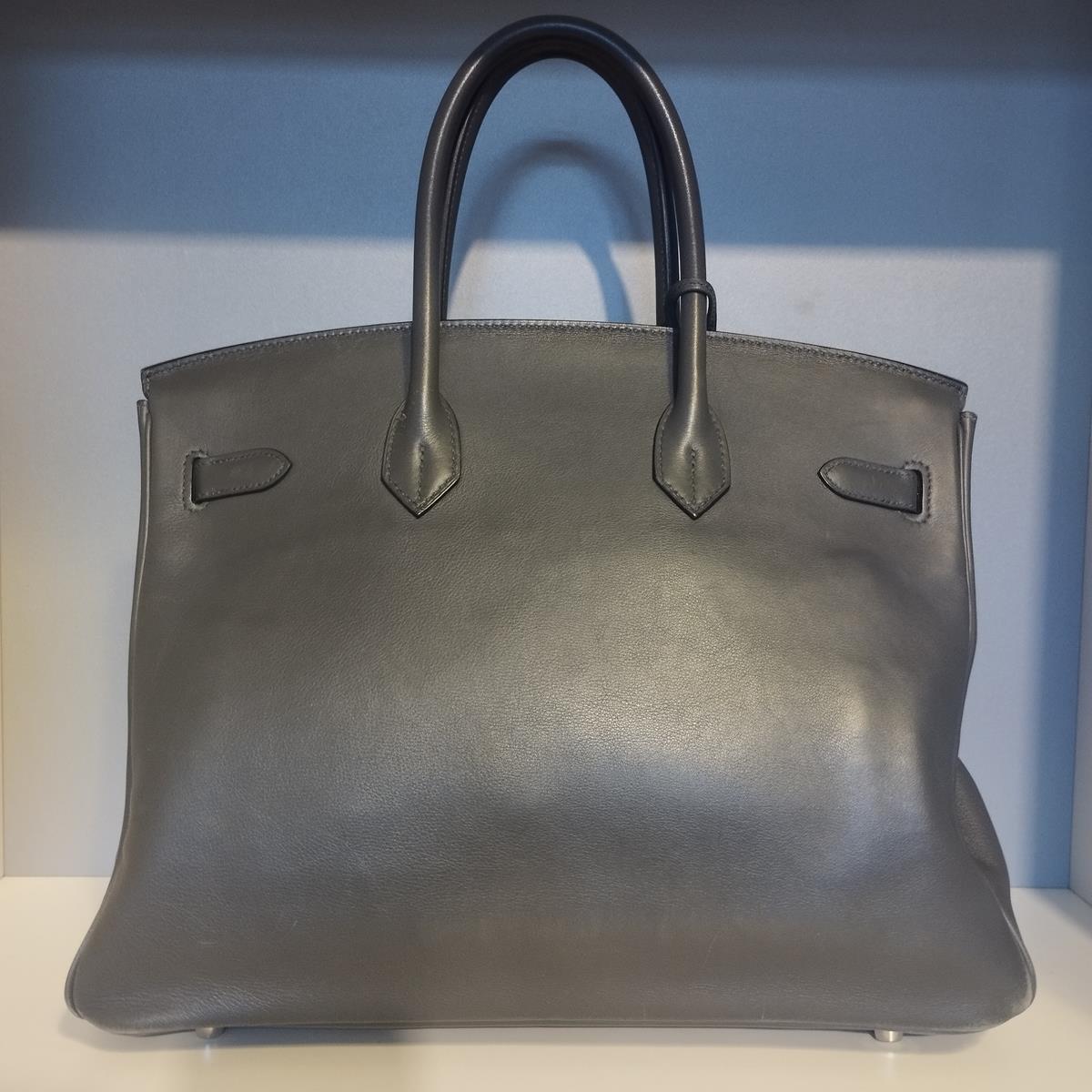 L'étonnant et emblématique sac Birkin 35 
Boîte en cuir
Gris anthracite
Quincaillerie en palladium
Année 2009
Série M
Double poignée
Clés et casier
2 poches intérieures (dont une avec fermeture éclair)
Cm 35 x 28 x 18 (13,7 x 11 x 7,08 pouces)
Bon