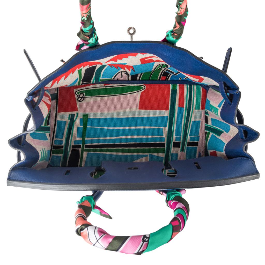 Guaranteed authentic very rare limited edition Hermes Birkin bag featured with interior toile is scarf print Sea Surf and Fun in blue red and pink colorway, designed by Filipe Jardim.  
Blue Sapphire Taurillon Novillo leather accentuates the deep