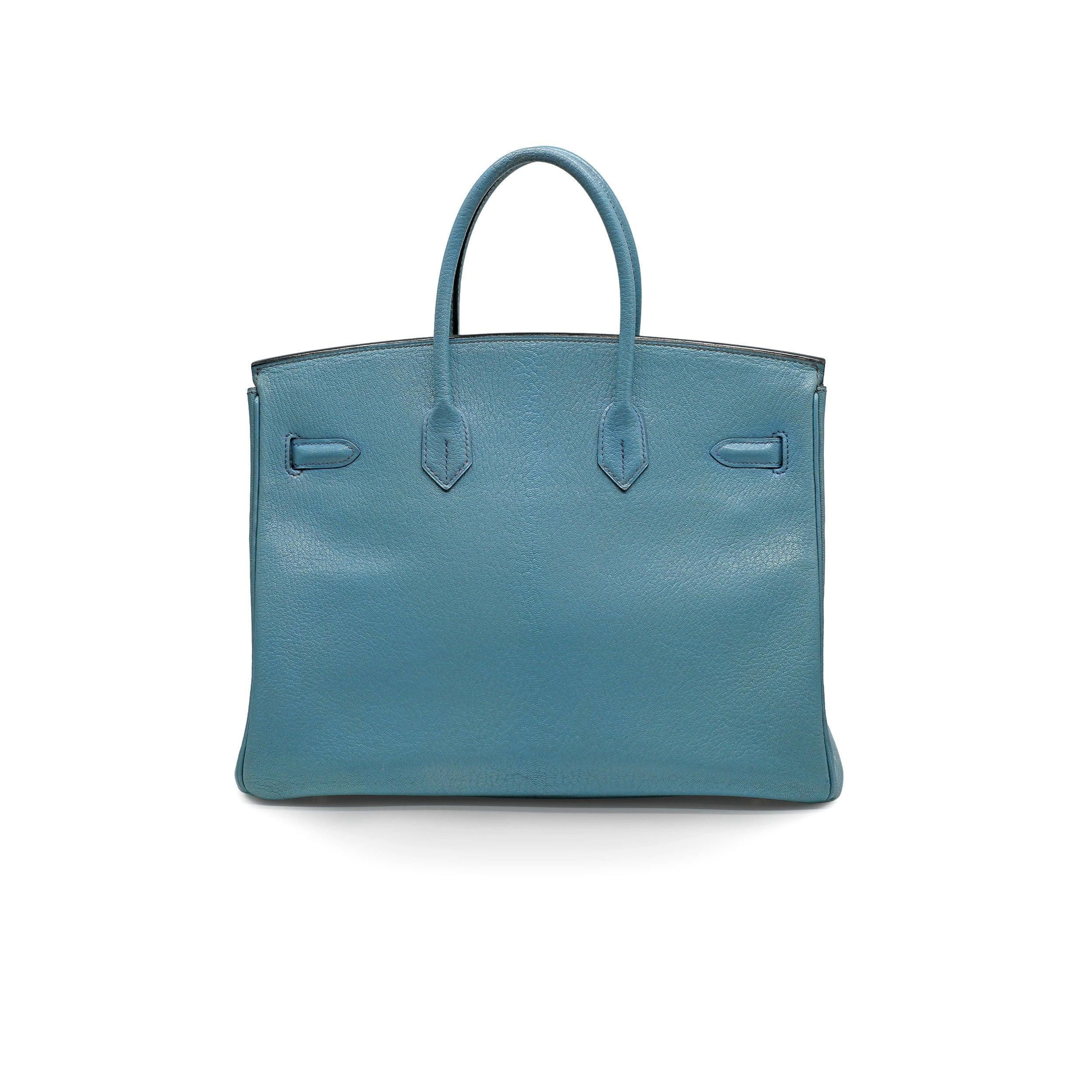 The Hermès Birkin 35 Blue Jean Chevre Leather bag is crafted from teal blue Togo leather and features two rolled top handles, signature sangles straps, and a foldover top with a twist-lock closure and padlock. The interior includes a main
