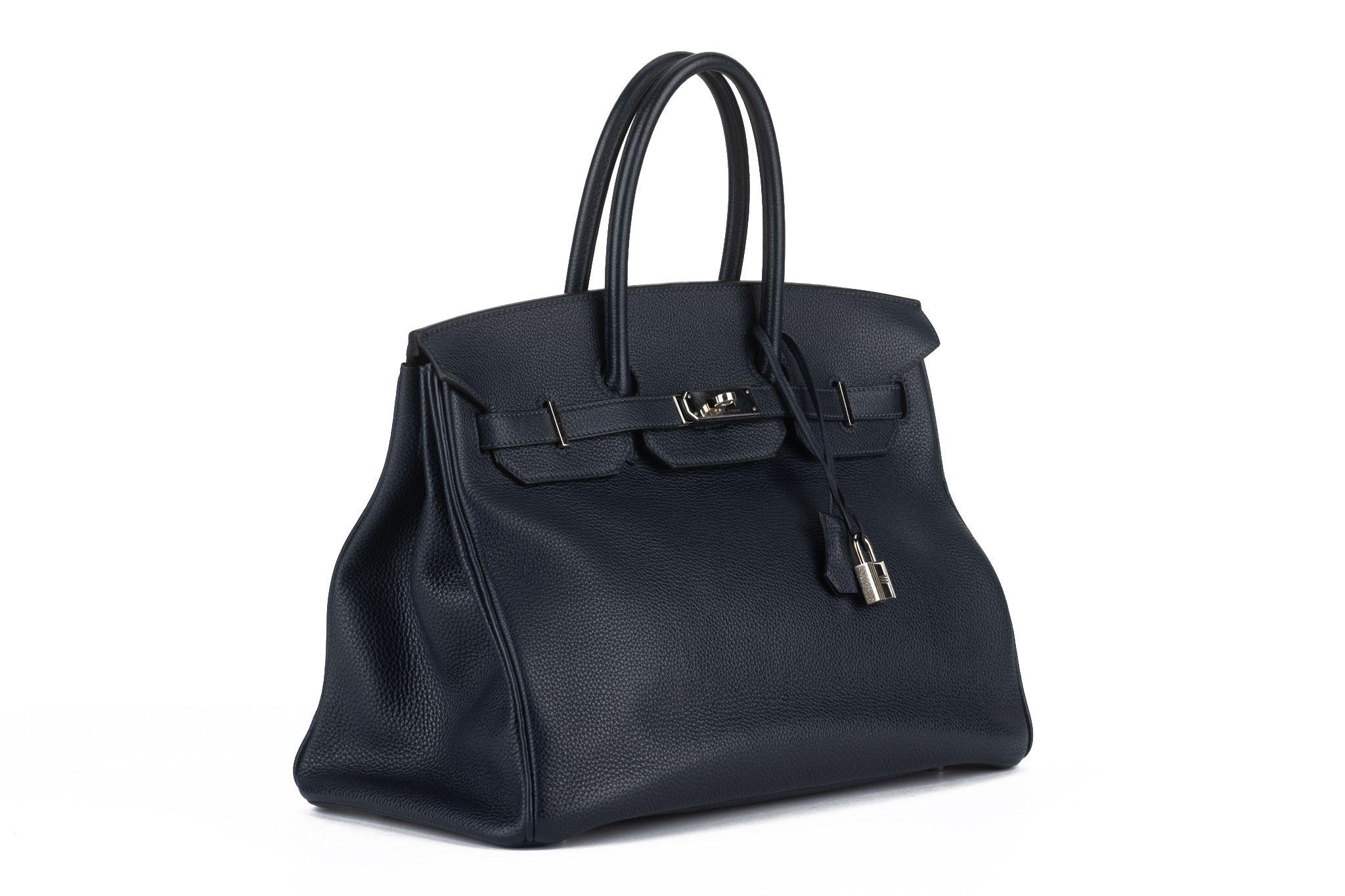 This Hermès Birkin 35 in blue nuit togo leather with palladium hardware and tonal stitching, Front flap, two straps with center toggle closure, a clochette with lock, two keys and double rolled handles. The interior is lined with chevre leather.
