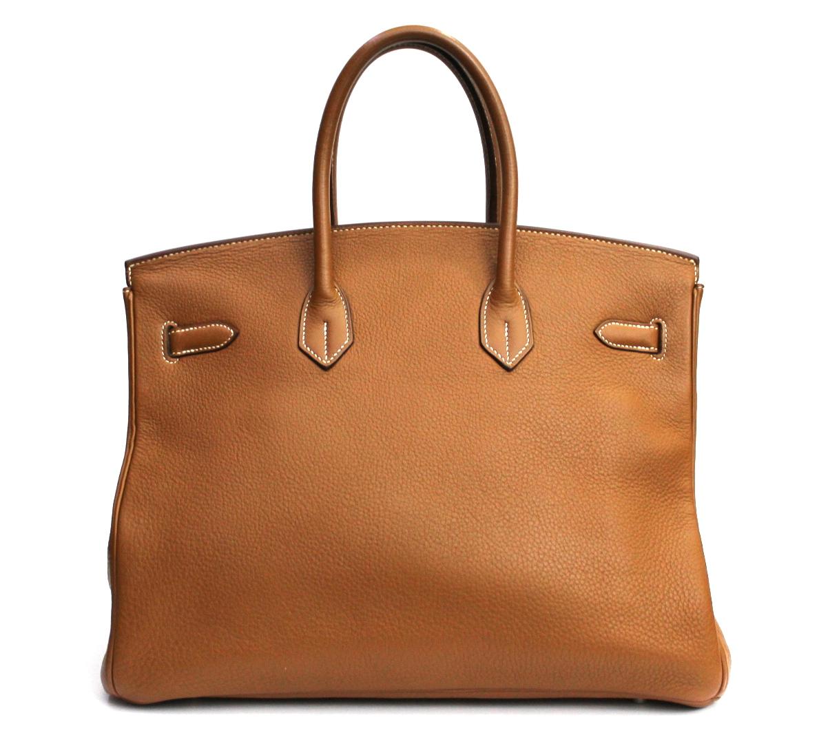 This Hermès Birkin 35cm is crafted from gold togo leather, a highly popular hide due to its ability to retain its shape and near-scratch resistance. Its deep, The gold exterior is offset with silver-toned palladium hardware. 35cm in width, the
