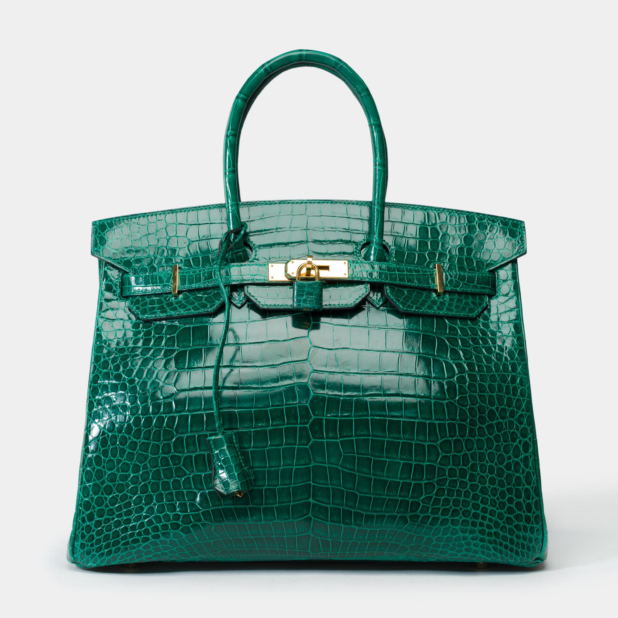 Fabulous​ ​Hermès​ ​Birkin​ ​35​ ​cm​ ​handbag​ ​in​ ​emerald​ ​green​ ​Porosus​ ​crocodile,​ ​with​ ​gold-tone​ ​hardware,​ ​and​ ​double​ ​green​ ​Porosus​ ​crocodile​ ​handles​ ​for​ ​hand​ ​carry

Flap​ ​closure
Green​ ​leather​ ​interior​