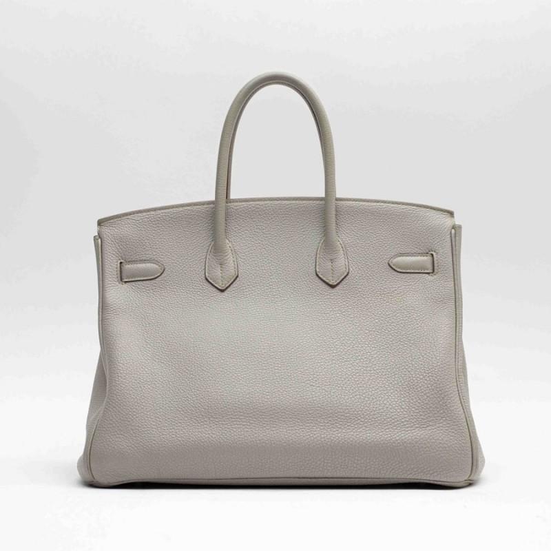 The timeless Birkin bag from Maison HERMES is in dove gray togo leather. This color is unique, and is easy to combine with any garment. The jewelry is made of palladium silver metal. It has a padlock, zipper, bell and keys. Worn on the arm or by