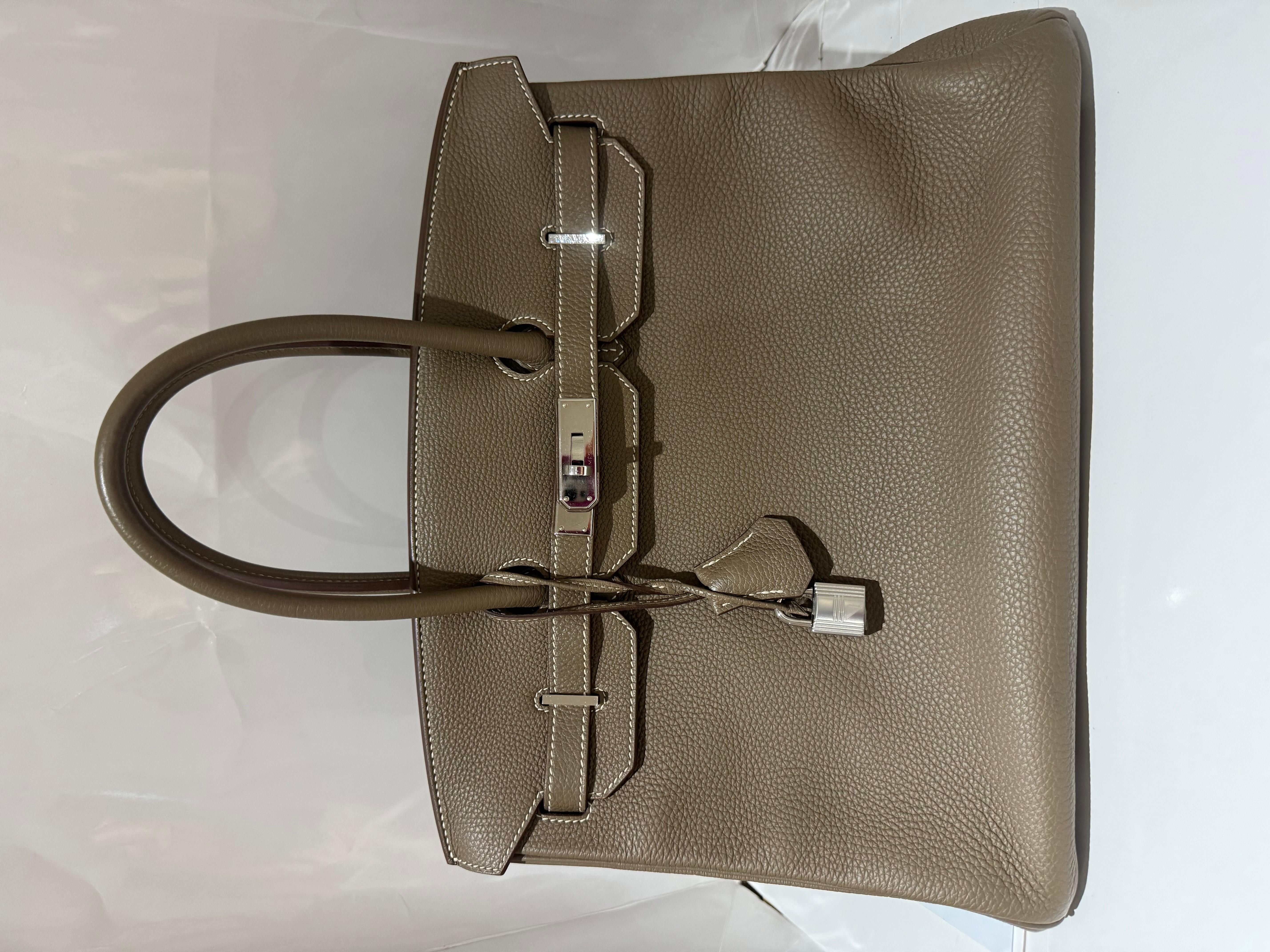 Borsa Hermes Birkin 35 Etoupe in pelle di togo con finiture in palladio. Una borsa molto classica per un look senza tempo. Timbro R 
Viene fornito con sacchetto antipolvere, lucchetto e chiavi.

Altezza: 9,45 pollici / 24 cm
Larghezza: 13,78 pollici