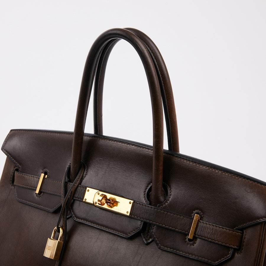 Iconic bag, Birkin 35 HERMES in brown barénia calfskin.
The jewelry is in gold metal. It has a padlock, zipper, bell and keys. At the back of the left tab we find the year of manufacture. The interior is in brown leather with two large flat pockets