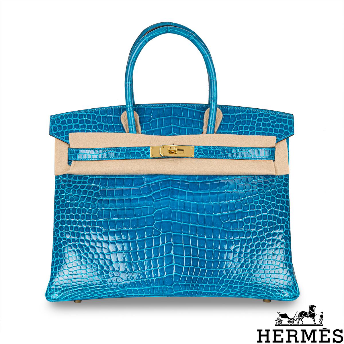 Un incroyable sac Hermès Birkin de 35 cm. L'extérieur de ce Birkin exotique est en crocodile poreux Bleu Izmir brillant avec des surpiqûres ton sur ton. Il est orné de matériel de couleur dorée, de deux poignées supérieures et d'une fermeture à