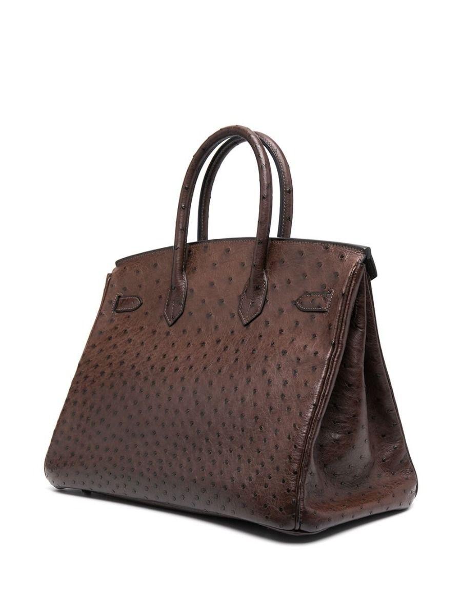 Aggiungendo un tocco alla tradizionale Birkin di Hermès, questa rarità davvero spettacolare e unica nel suo genere mostra un esterno dai toni marrone terra, realizzato in pelle di struzzo. Questa pelle è la più rara e ambita tra le pelli esotiche e