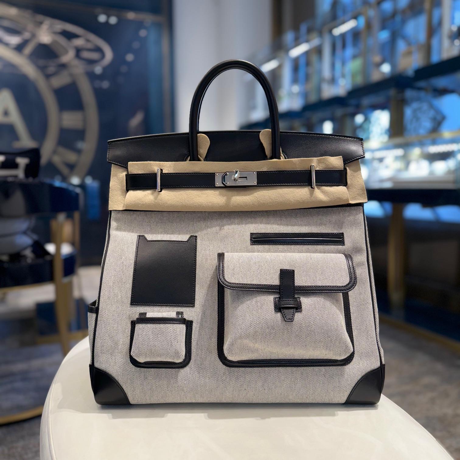 Jewels Aficionado offers an Hermes Birkin 40 Hac A Courroies Cargo Bag AA Ecru-Noir/Noir Palladium

This is not your average Birkin—the HAC (Haut à Courroies) Cargo 40 is a rugged, ultra-functional, and impossibly rare collector’s piece designed for