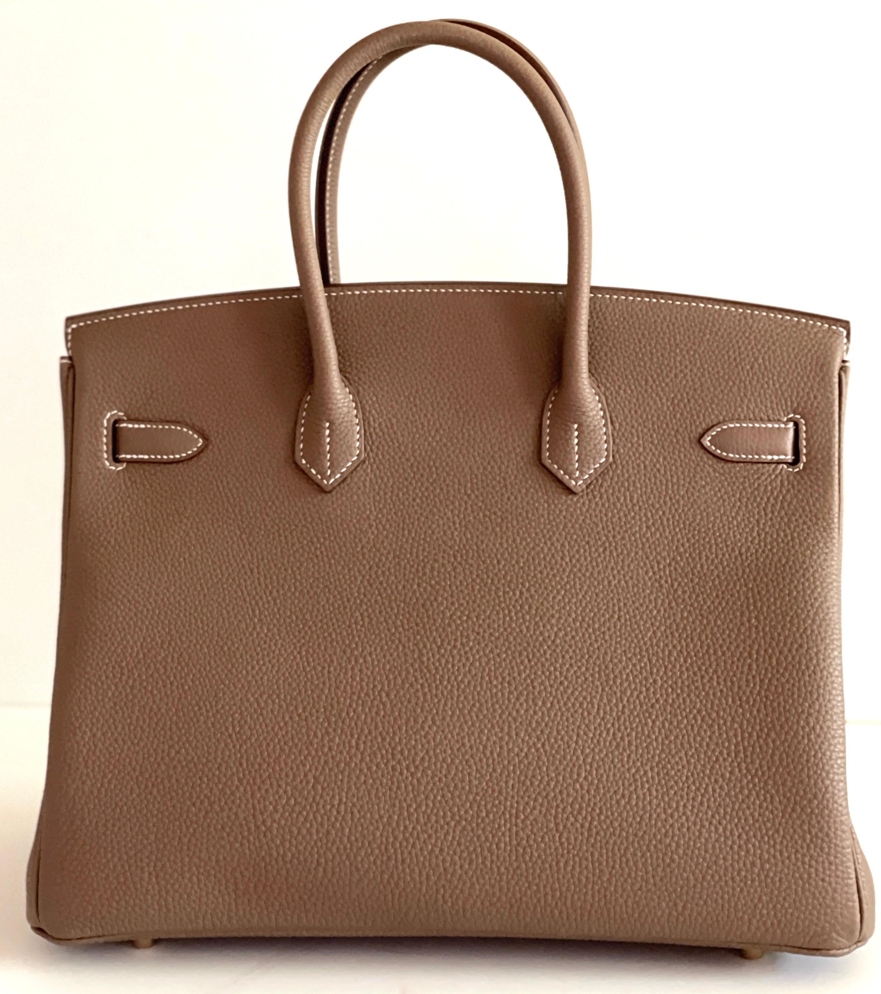 HERMÈS
Togo Etoupe  Birkin 35
Etoupe togo with contrasting white top stitching detail
 
Description
Hermes 35cm Birkin Etoupe, always a favorite with the Hermes Collector, and one of the first colors collected!

Gold Hardware

Togo Leather love by