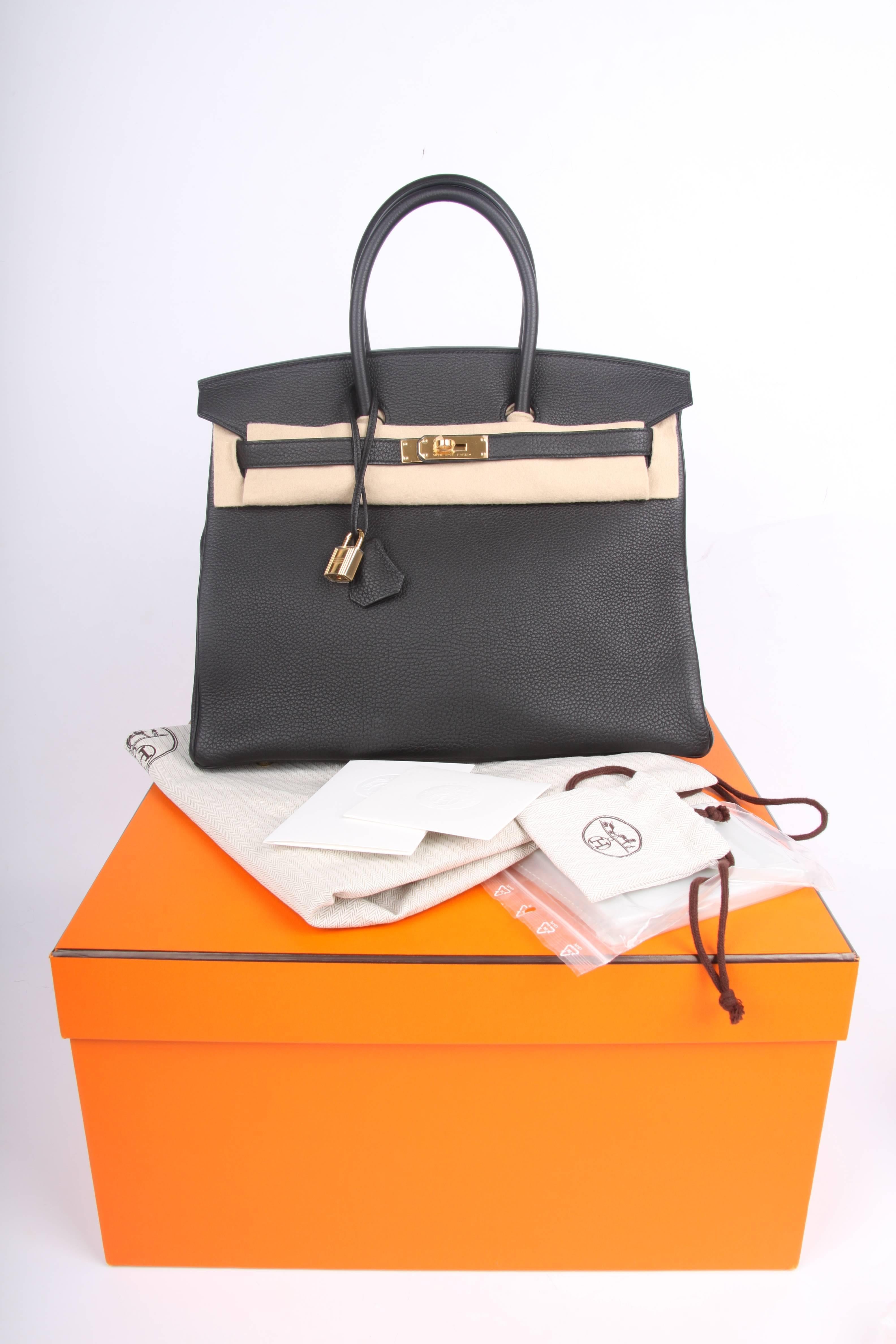 Brand new is this Hermès Birkin Bag 35 in Togo leather with goldtone hardware, this color is Noir. It's as black as the night!

Front toggle closure, clochette with lock and two keys, and double rolled handles. The Togo leather has a visible grain,