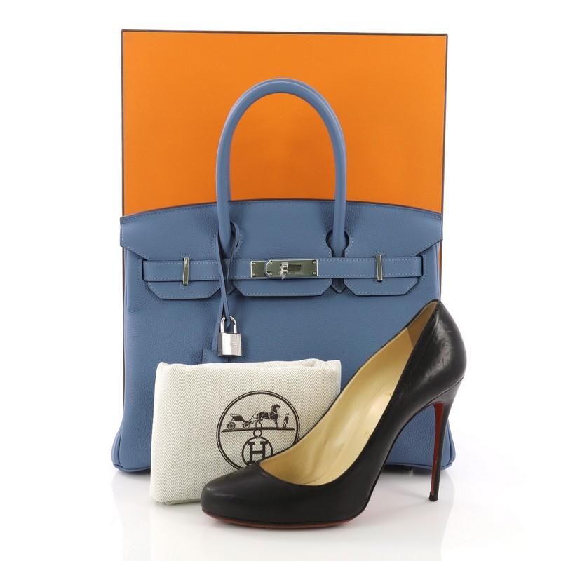 This Hermes Birkin Handbag Azur Togo with Palladium Hardware 30, crafted in Azur blue togo leather, features dual rolled handles, front flap, and palladium-tone hardware. Its turn-lock closure opens to a blue leather interior with slip and zip