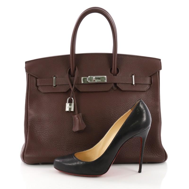 This Hermes Birkin Handbag Bicolor Clemence with Palladium Hardware 35, crafted in Chocolate brown clemence leather, features dual rolled handles, front flap and palladium-tone hardware. Its turn-lock closure opens to a Noisette brown leather
