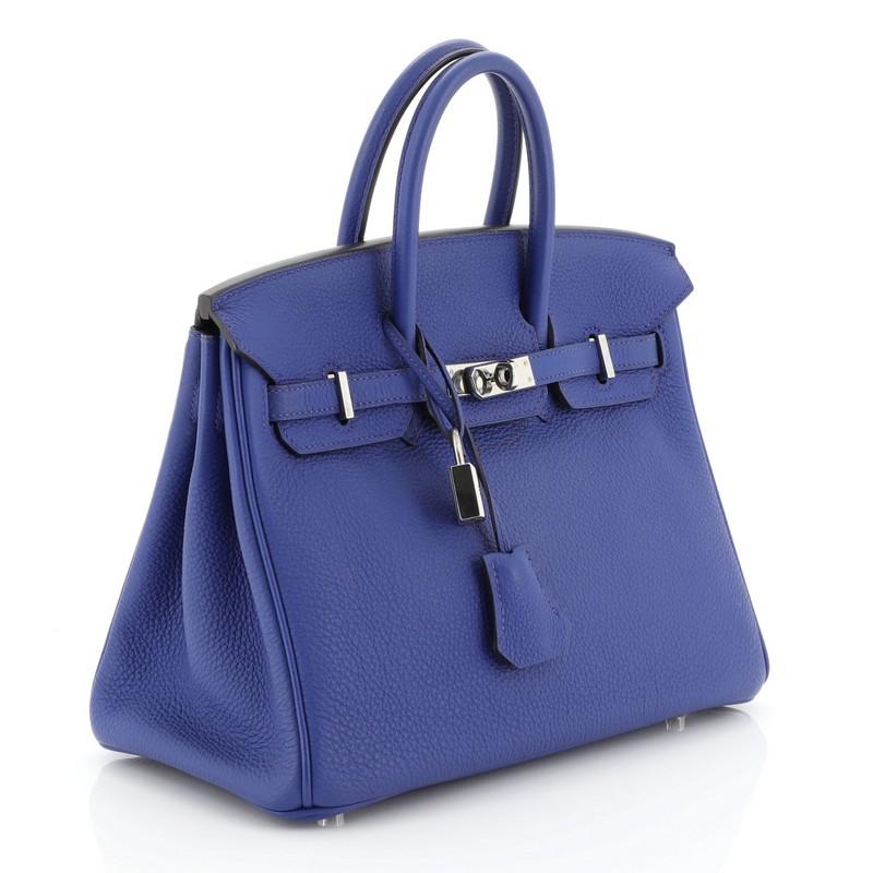 This Hermes Birkin Handbag Bleu Electrique Togo with Palladium Hardware 25, crafted in Bleu Electrique blue Togo leather, features dual rolled top handles, frontal flap, and palladium hardware. Its turn-lock closure opens to a Bleu Electrique blue