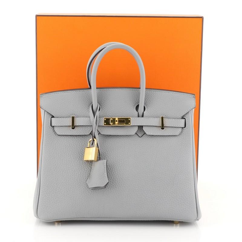 This Hermes Birkin Handbag Bleu Glacier Togo With Gold Hardware 25, crafted in Bleu Glacier Togo leather, features dual rolled handles, frontal flap, and gold hardware. Its turn-lock closure opens to a Bleu Glacier Chevre leather interior with zip
