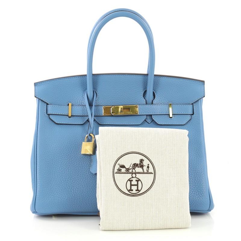 This Hermes Birkin Handbag Bleu Paradis Clemence with Gold Hardware 30, crafted in Bleu Paradis blue Clemence leather, features dual rolled handles, frontal flap, and gold hardware. Its turn-lock closure opens to a Bleu Paradis blue Chevre leather