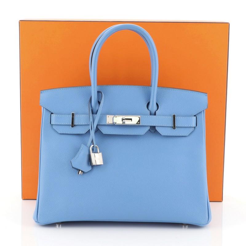 This Hermes Birkin Handbag Bleu Paradis Epsom with Palladium Hardware 30, crafted in Bleu Paradis blue Epsom leather, features dual rolled handles, frontal flap, and palladium hardware. Its turn-lock closure opens to a Bleu Paradis blue Chevre