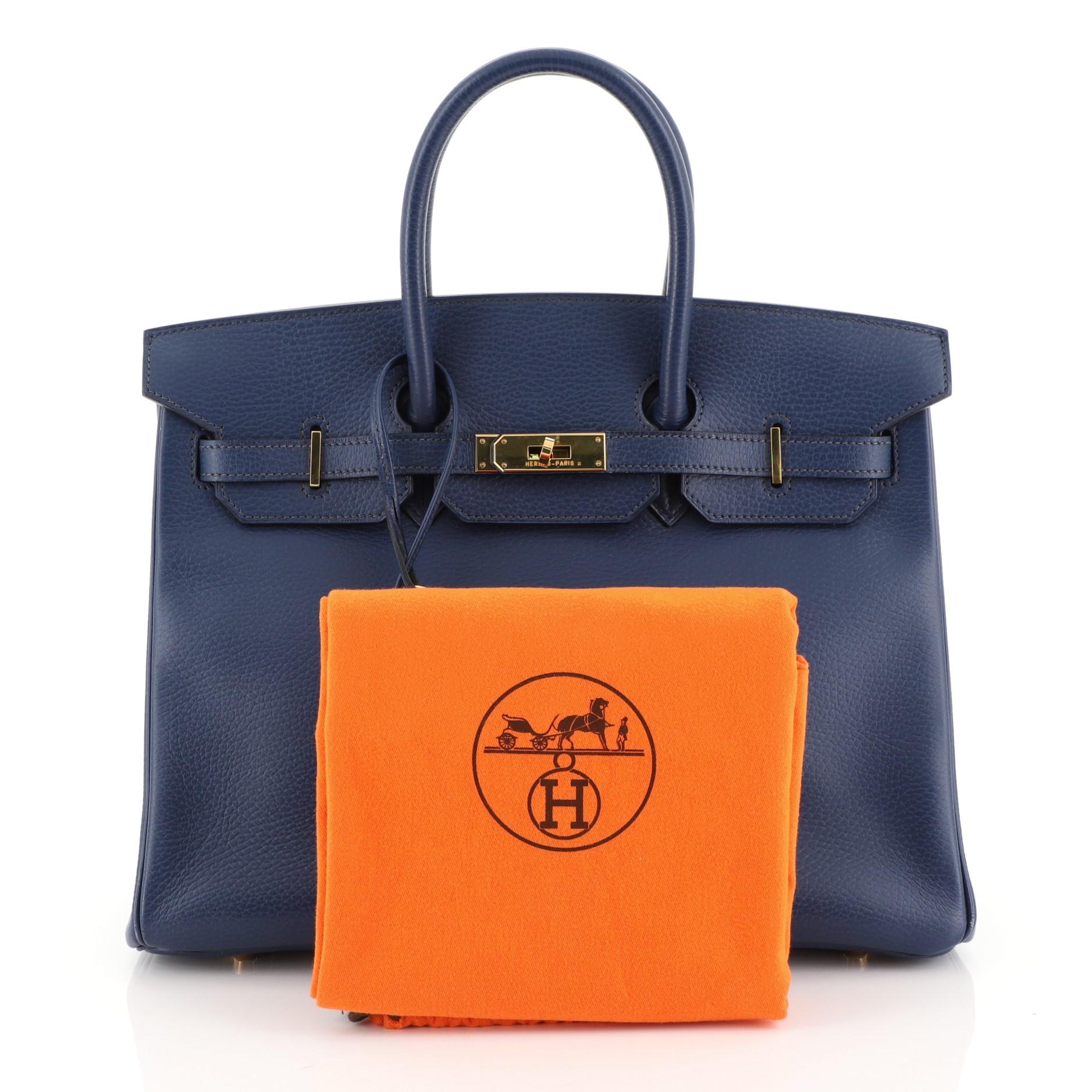 This Hermes Birkin Handbag Bleu Saphir Ardennes with Gold Hardware 35, crafted in Bleu Saphir blue Ardennes leather, features dual rolled handles, frontal flap, and gold hardware. Its turn-lock closure opens to a Bleu Saphir blue Chevre leather