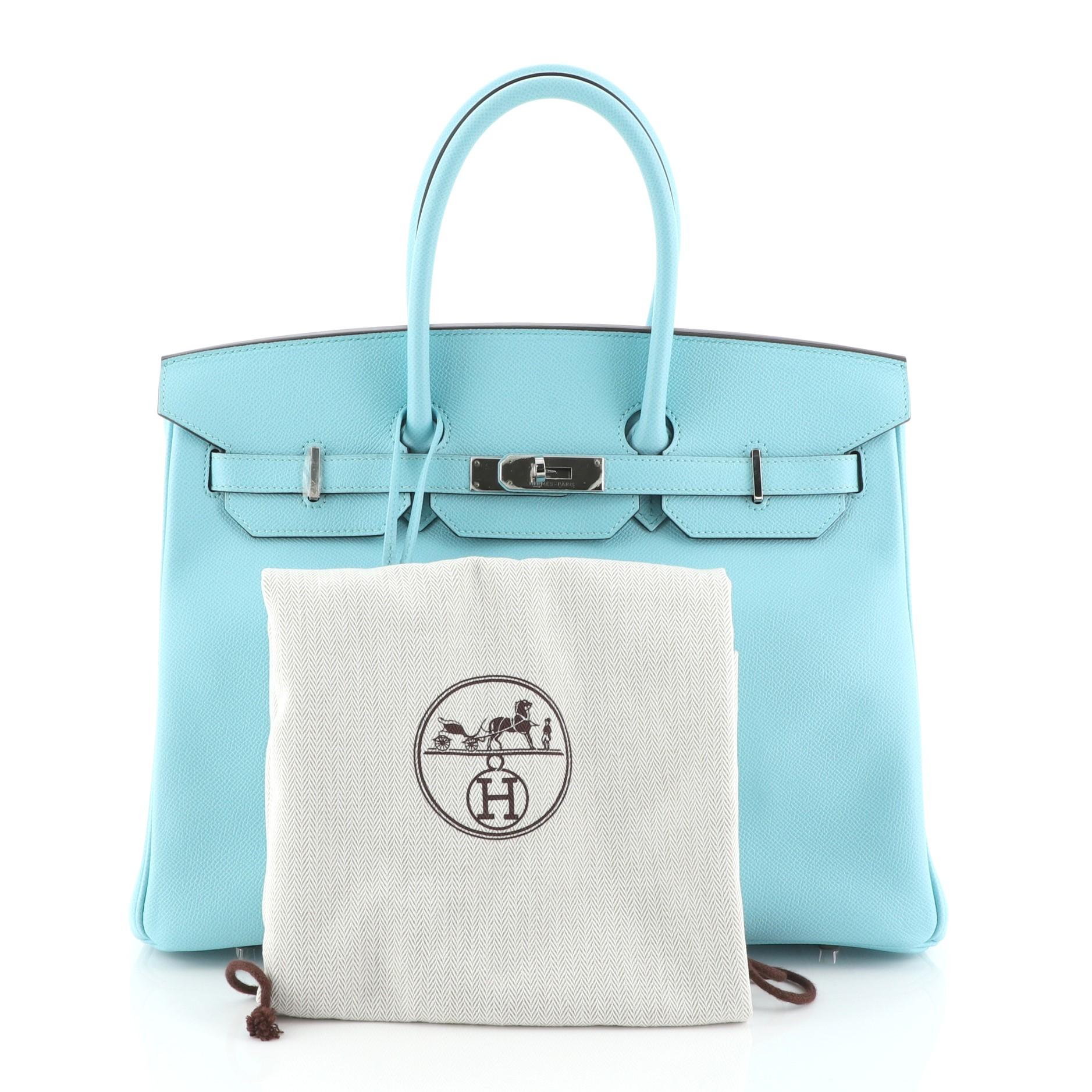 This Hermes Birkin Handbag Blue Atoll Epsom with Palladium Hardware 35, crafted in Bleu Atoll blue Epsom leather, features dual rolled top handles, frontal flap, and palladium hardware. Its turn-lock closure opens to a Bleu Atoll blue Chevre leather