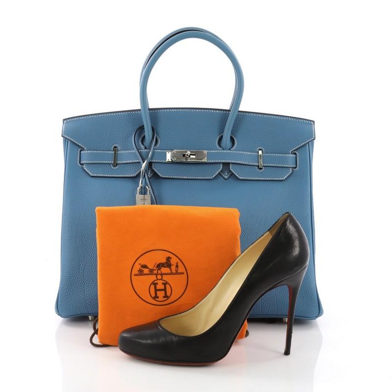 This Hermes Birkin Handbag Blue Jean Togo with Palladium Hardware 35, crafted in blue jean togo leather, features dual rolled handles, front flap and palladium-tone hardware. Its turn-lock closure opens to a blue leather interior with slip and zip