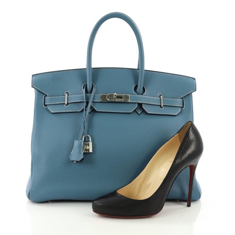 This Hermes Birkin Handbag Blue Jean Togo with Palladium Hardware 35, crafted from Blue Jean togo leather, features dual rolled handles, front flap, and palladium-tone hardware. Its turn-lock closure opens to a matching blue leather interior with