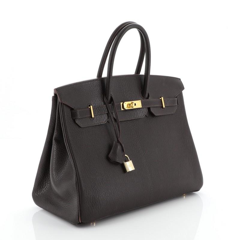 This Hermes Birkin Handbag Cacoan Chevre de Coromandel with Gold Hardware 35, crafted in Cacoan brown Chevre de Coromandel leather, this handbag features dual rolled top handles, frontal flap, and gold hardware. Its turn-lock closure opens to a
