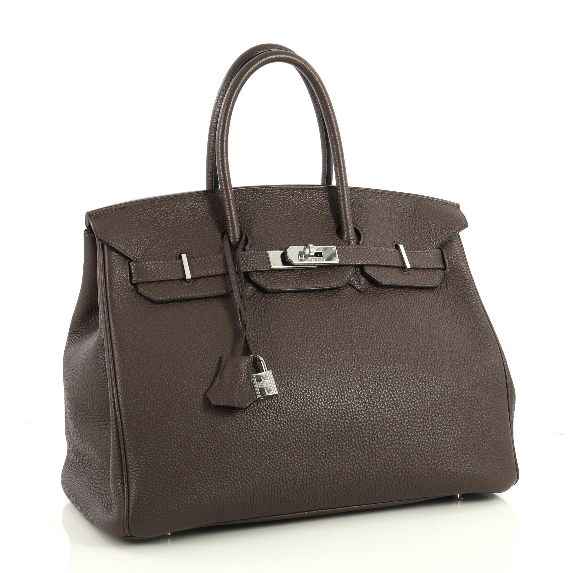 This Hermes Birkin Handbag Cafe Togo with Palladium Hardware 35, crafted in Cafe brown Togo leather, features dual rolled handles, front flap and palladium hardware. Its turn-lock closure opens to a Cafe brown Chevre leather interior with slip and