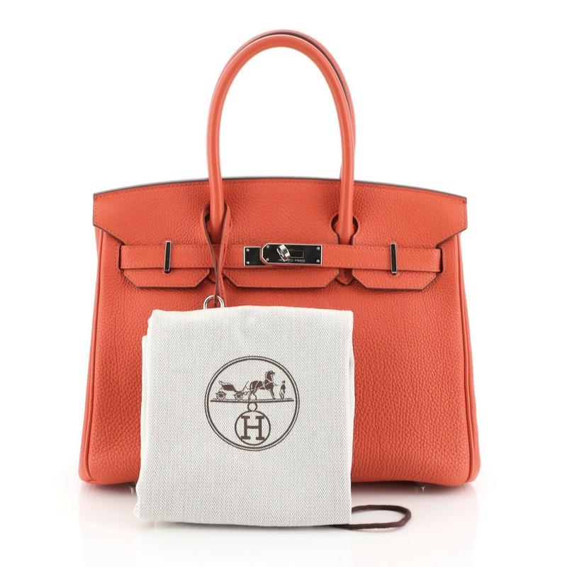 This Hermes Birkin Handbag Capucine Togo with Palladium Hardware 30, crafted in Capucine red Togo leather, features dual rolled handles, frontal flap, and palladium hardware. Its turn-lock closure opens to a Capucine red Chevre leather interior with
